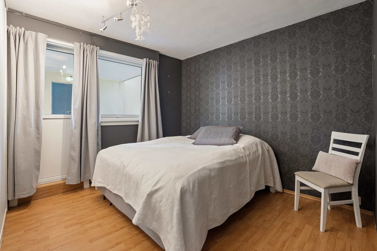 Det ene av to soverom, utstyrt med laminatgulv og en praktisk skyvedørsgarderobe for effektiv oppbevaring. Galleribilde