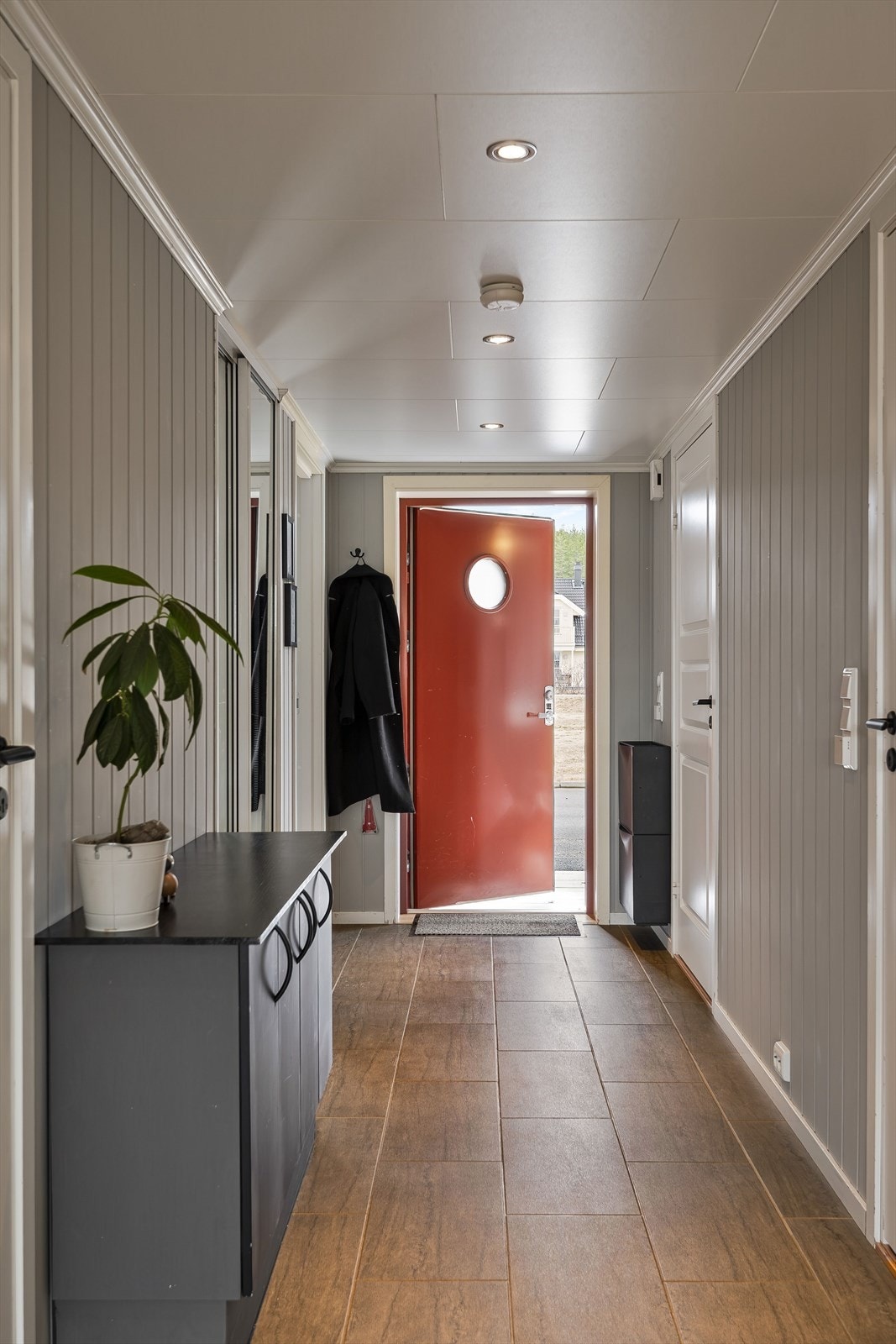 Når du entrer leiligheten, kommer du inn i en innbydende entré. Her har du god oppbevaringsplass i plassbygget skyvedørsgarderobe med speildører, samt ytterligere plass til oppheng av yttertøy, skoskap og kommode. Galleribilde