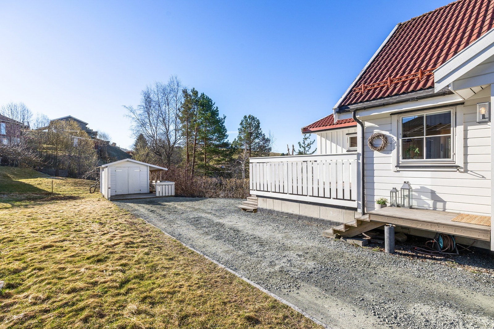 Hyggelig inngangsparti og trapp opp til en stor sørvest-vendt veranda. Utebod med lagringsplass. Galleribilde
