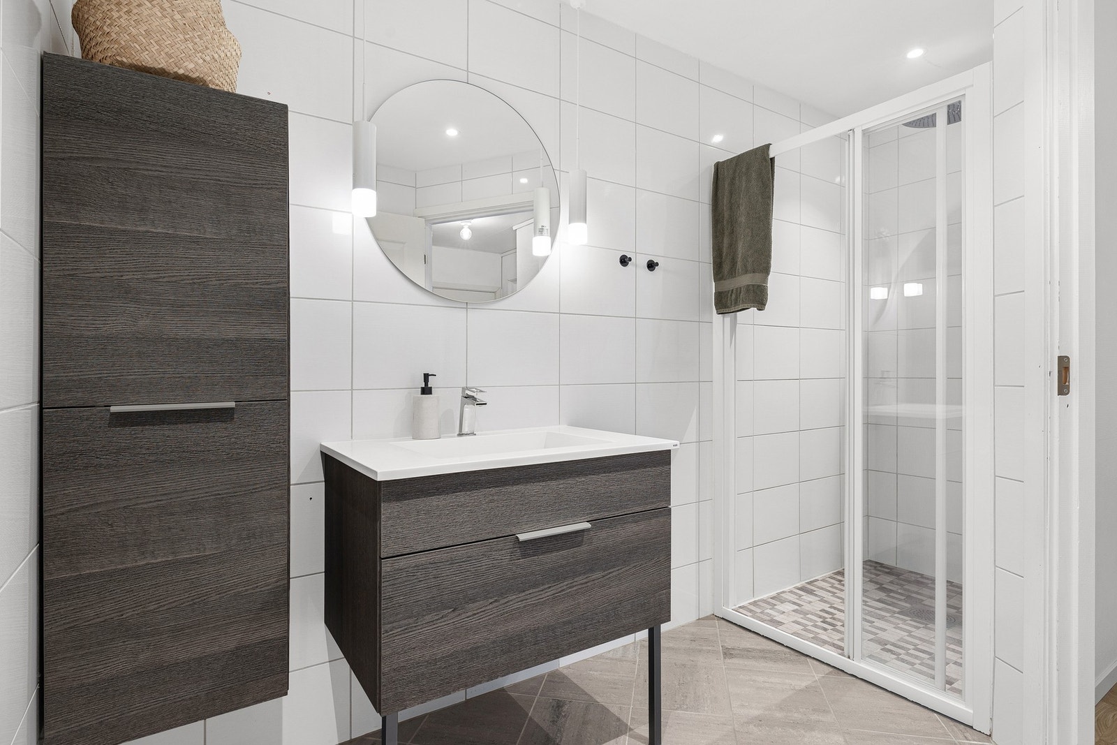 Badet har moderne baderomsinnredning, romslig dusjnisje og dekorative lamper ved speilet. Galleribilde