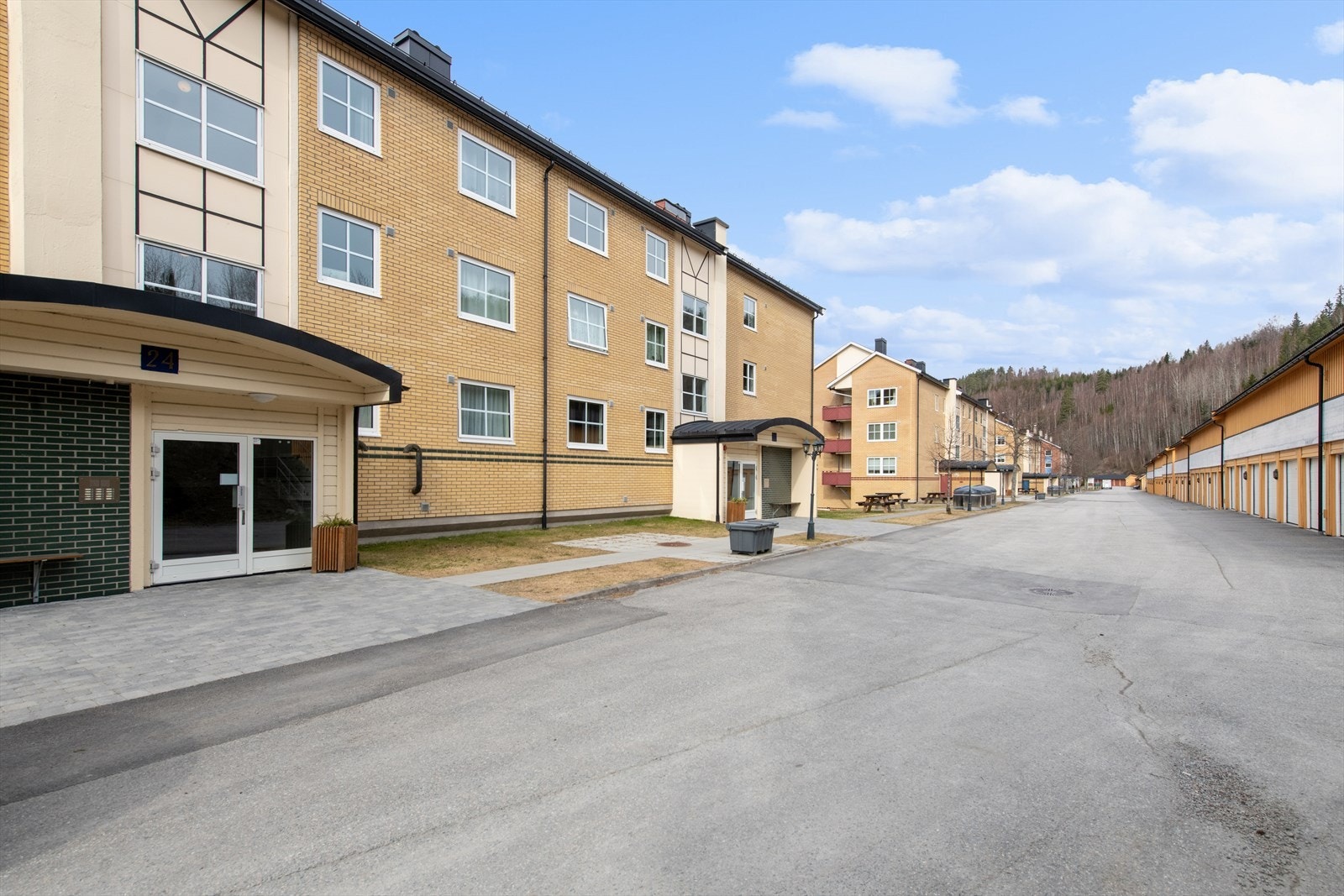 Fra felles inngangsparti er det en halv trapp ned til leiligheten. Pent opparbeidet utemiljø i borettslaget. Galleribilde