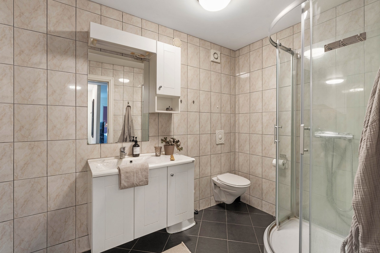 Badet i underetasjen er fra 2005 og har flislagt gulv med gulvvarme, dusjkabinett og opplegg for vaskemaskin. Galleribilde