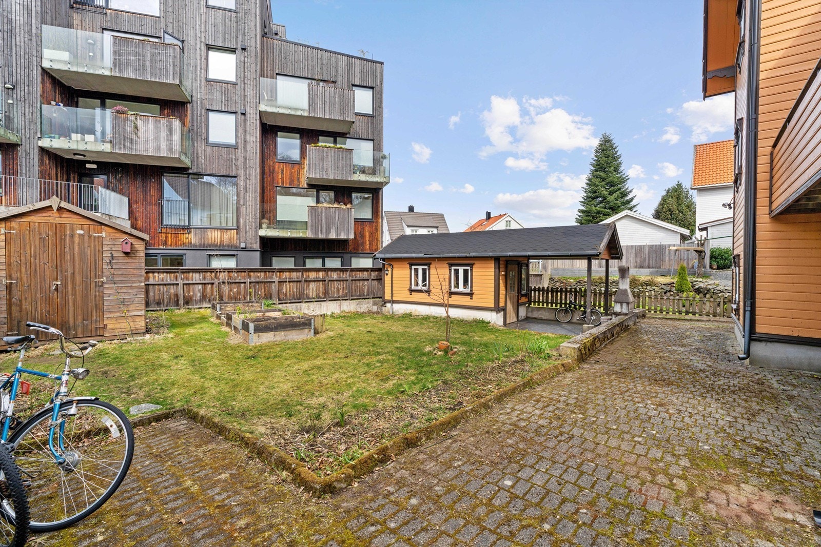 Felles uteområde med plen og belegningsstein. Galleribilde