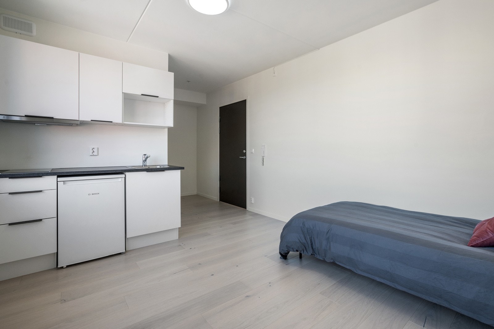 God plass til seng, garderobe og et lite spisebord. Galleribilde