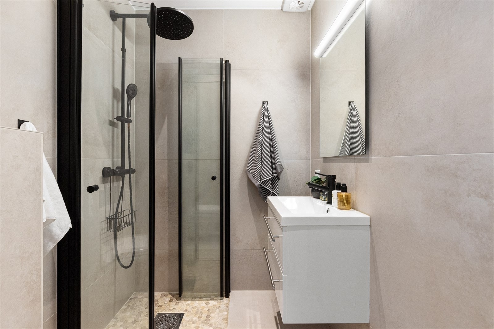Flislagt baderom som er pusset opp i 2023. Badet har fliser på gulv og vegger, og slette overflater i himling. Galleribilde