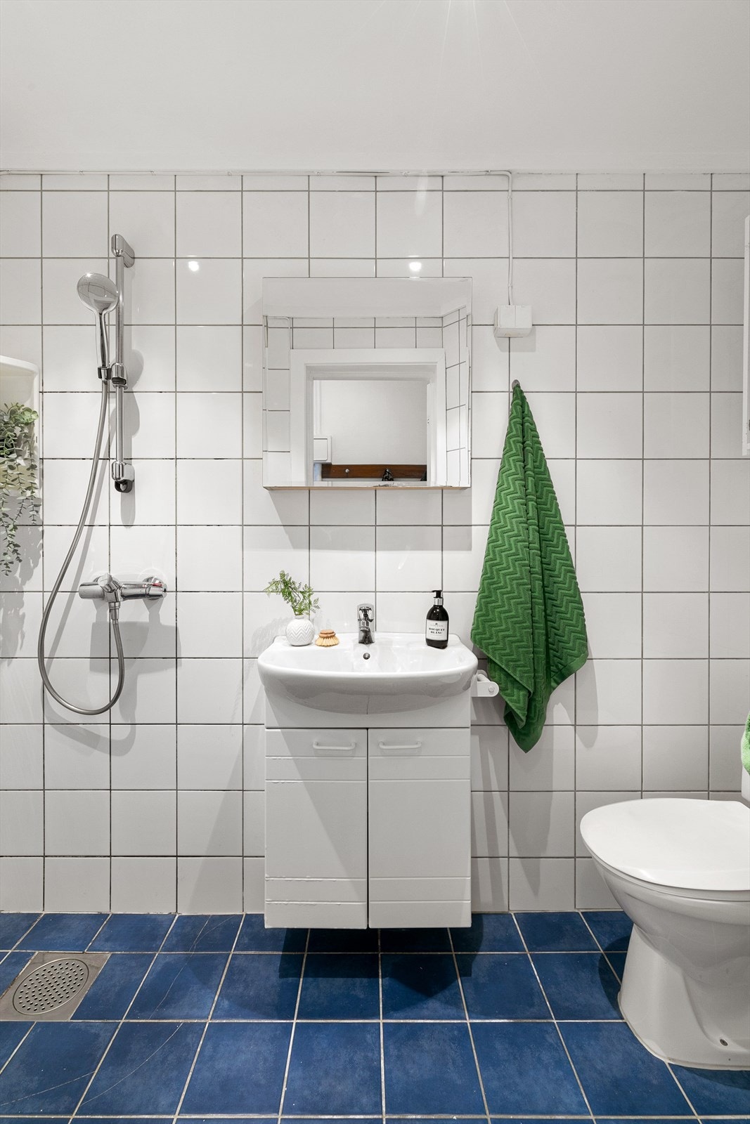 Badet er helfliset og utstyrt med underskap, overskap, servant, dusj, og toalett. Galleribilde