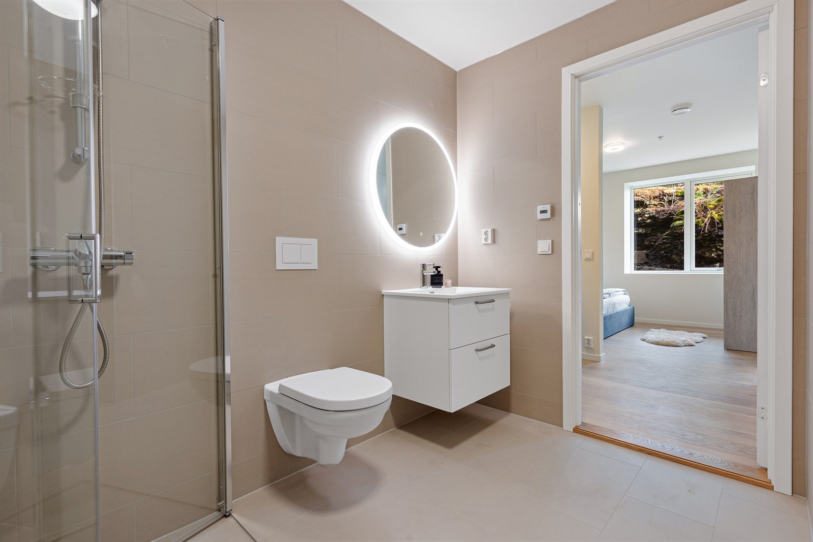 Badet er det innredet med dusjhjørne med glassdører, vegghengt toalett og servant med underskuffer og speil. Galleribilde