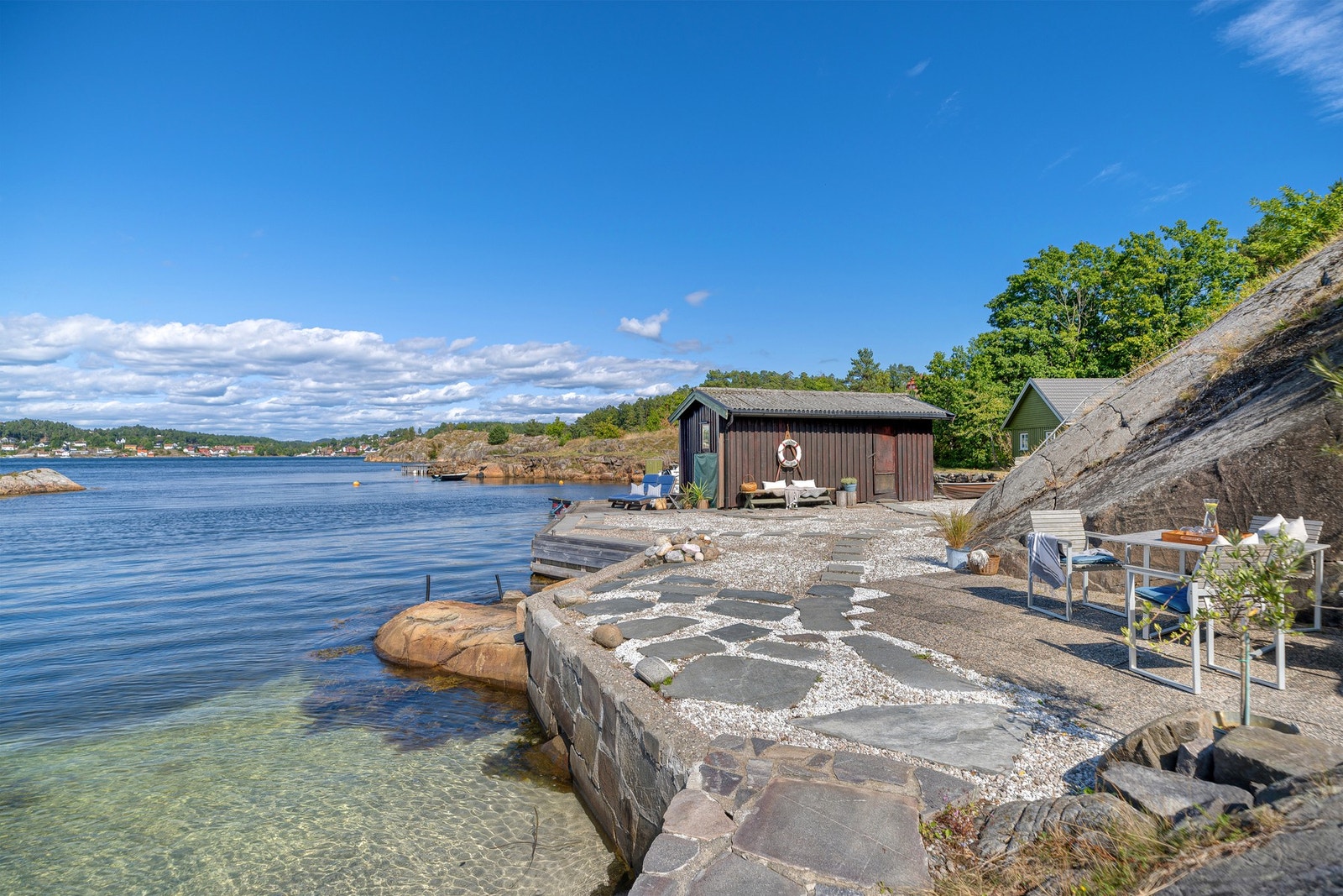 Langs sjøkanten er det etablert et innbydende uteområde som legger godt til rette for rolige dager helt nede ved vannet. Galleribilde