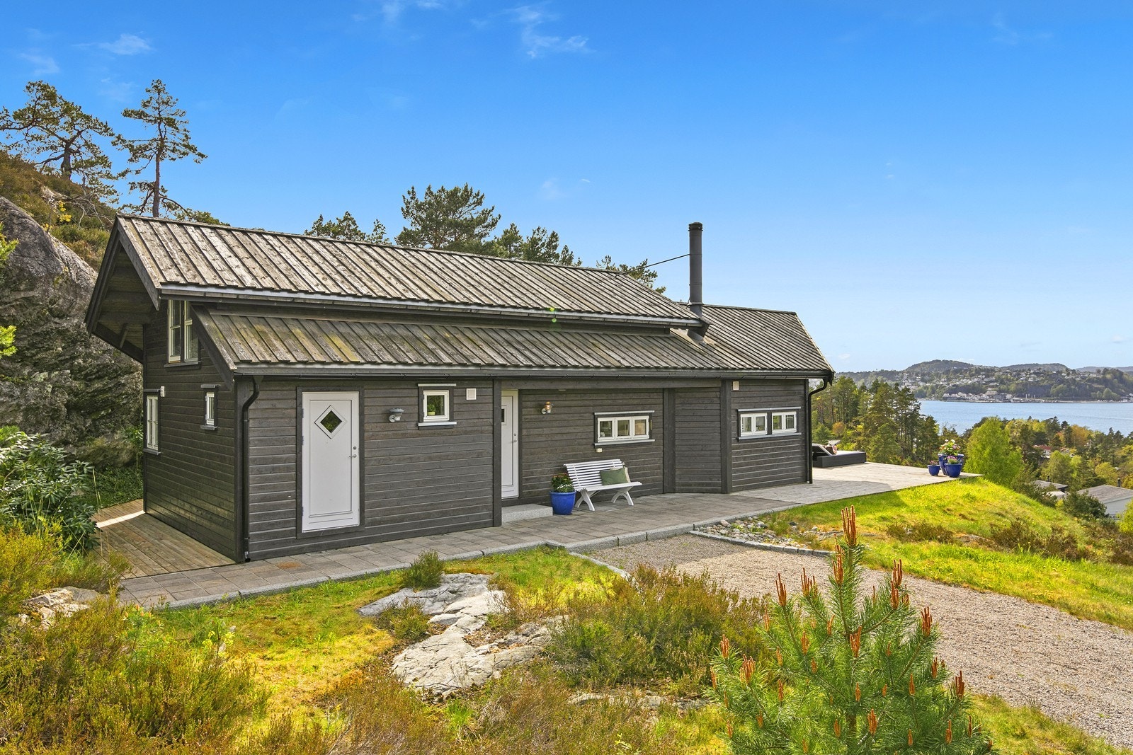 Tomten er opparbeidet med gruset adkomst og store terrasser i front. Galleribilde