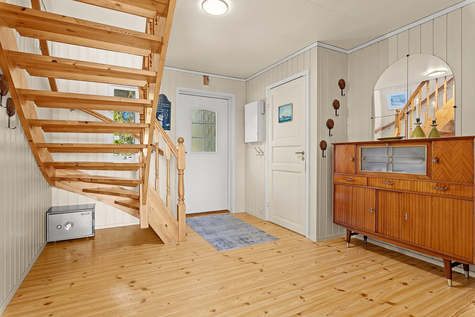 I 1. etasje kommer du først inn i boligens hall. Herfra er det videre adkomst til bad, vaskerom, kjøkken, stue/spisestue og oppgang til 2. etasje. Galleribilde