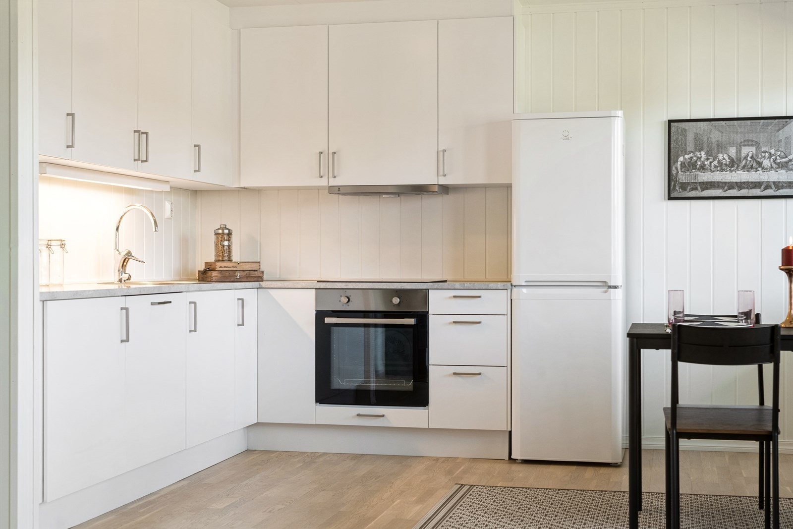 Kjøkkeninnredningen har glatte fronter, takhøye overskap og laminat benkeplate med nedfelt oppvaskkum med 1-greps blandebatteri. Galleribilde