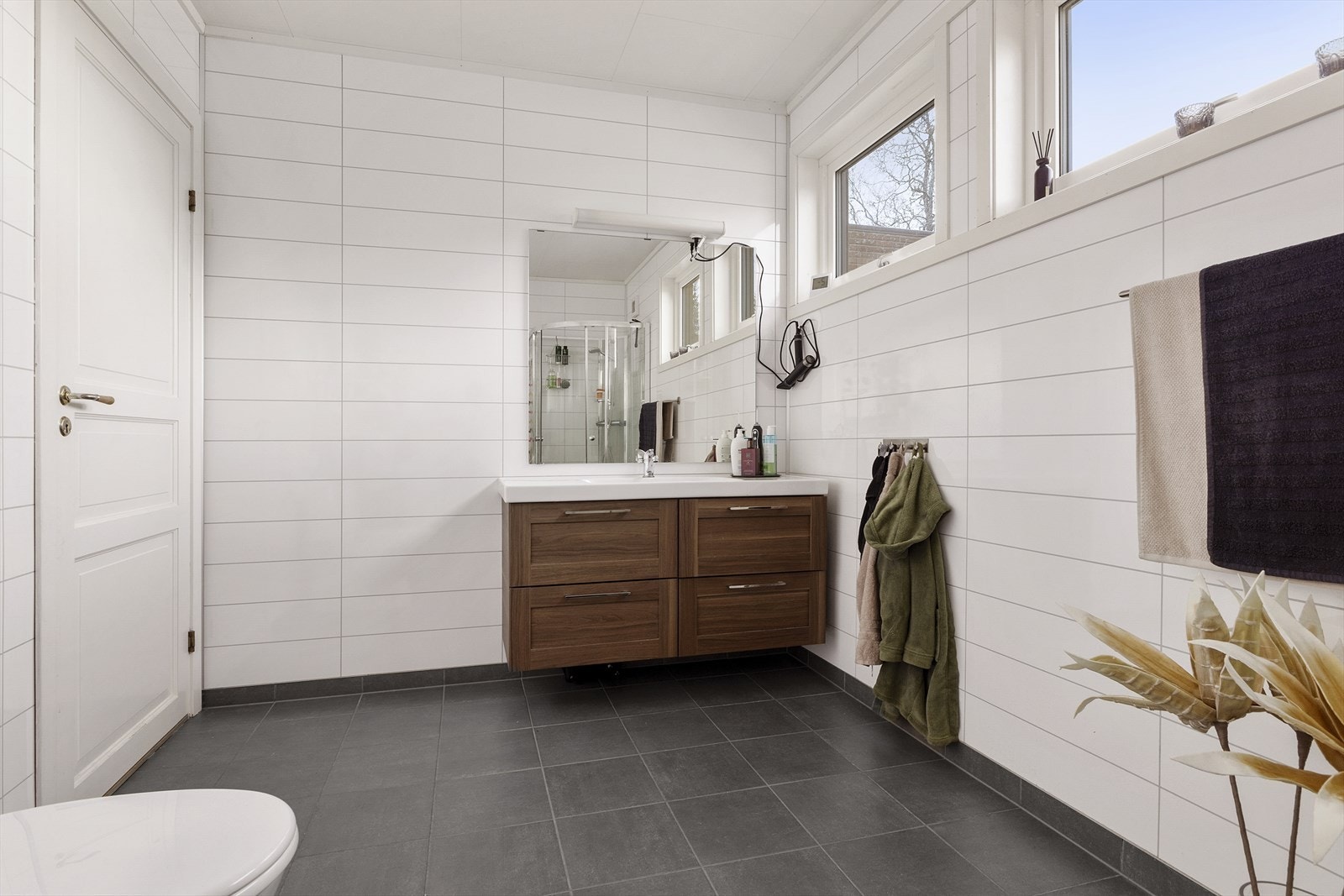 Badet er romslig og inneholder baderomsinnredning med servant, toalett, dusjkabinett og opplegg for vaskemaskin. Galleribilde