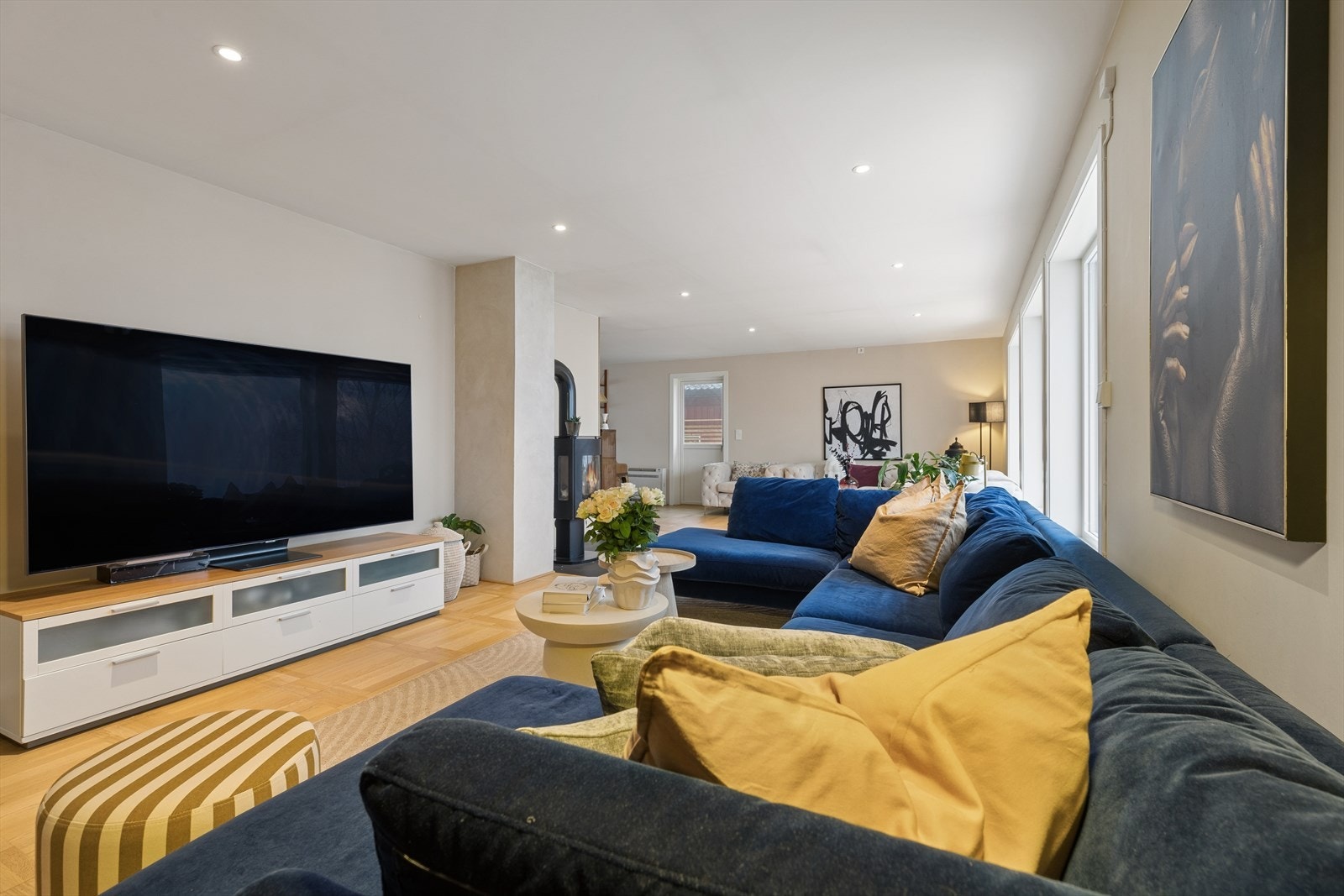 Flott gulv, vegger malt i duse farger, store vindusflater og utstrakt bruk av downlights sørger for en hyggelig atmosfære i rommet. Galleribilde