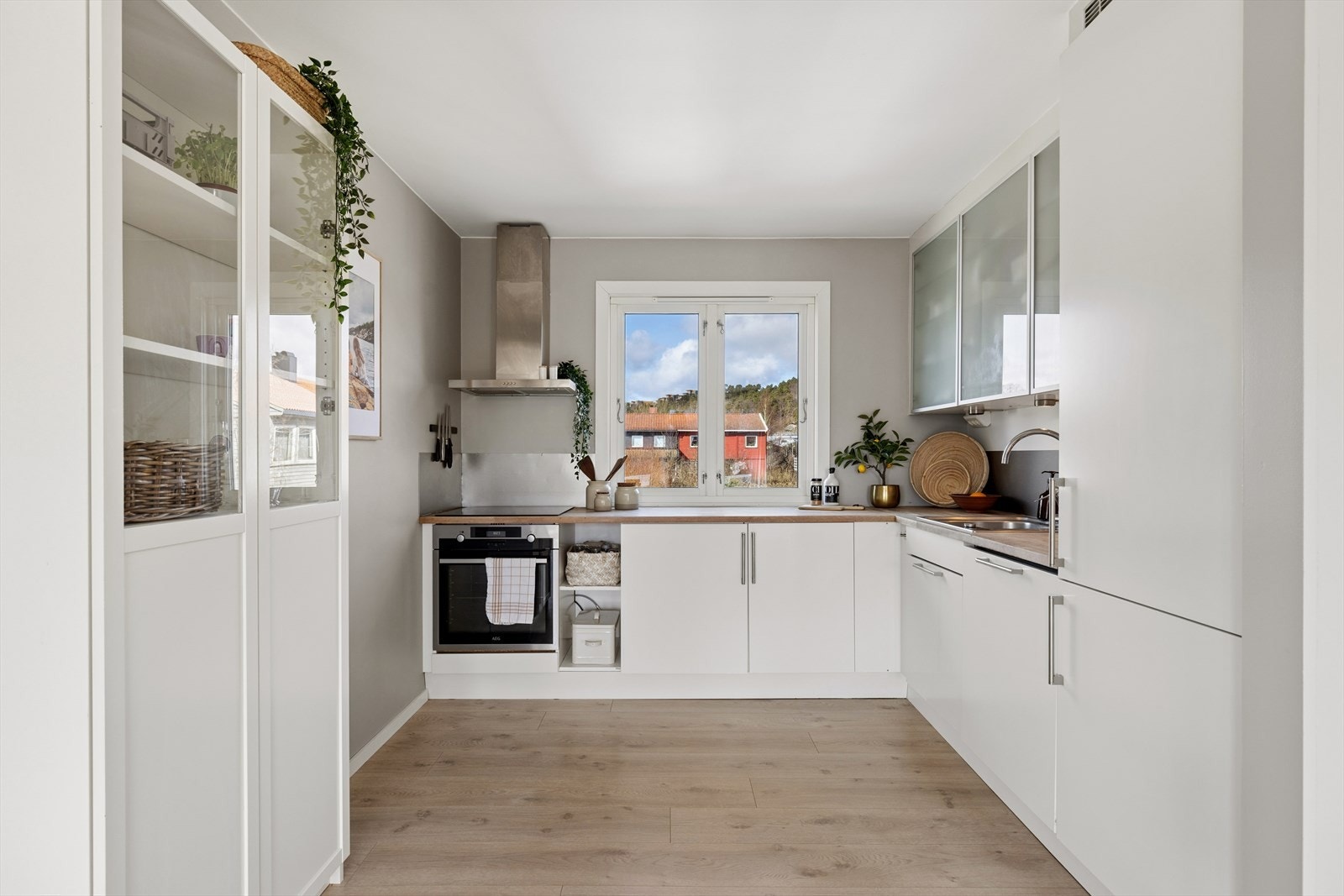 Stilrent og moderne kjøkken med hvite slette fronter og benkeplate i solid heltre. Galleribilde
