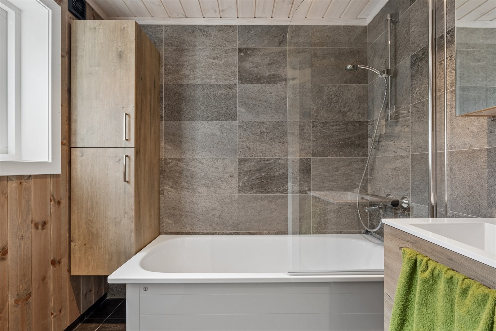 Hytta har et delikat bad med flislagte gulv med varmekabler. Veggene har trepanel, med unntak av i dusjsonen hvor det er fliser. På badet er det urinal-toalett. Galleribilde