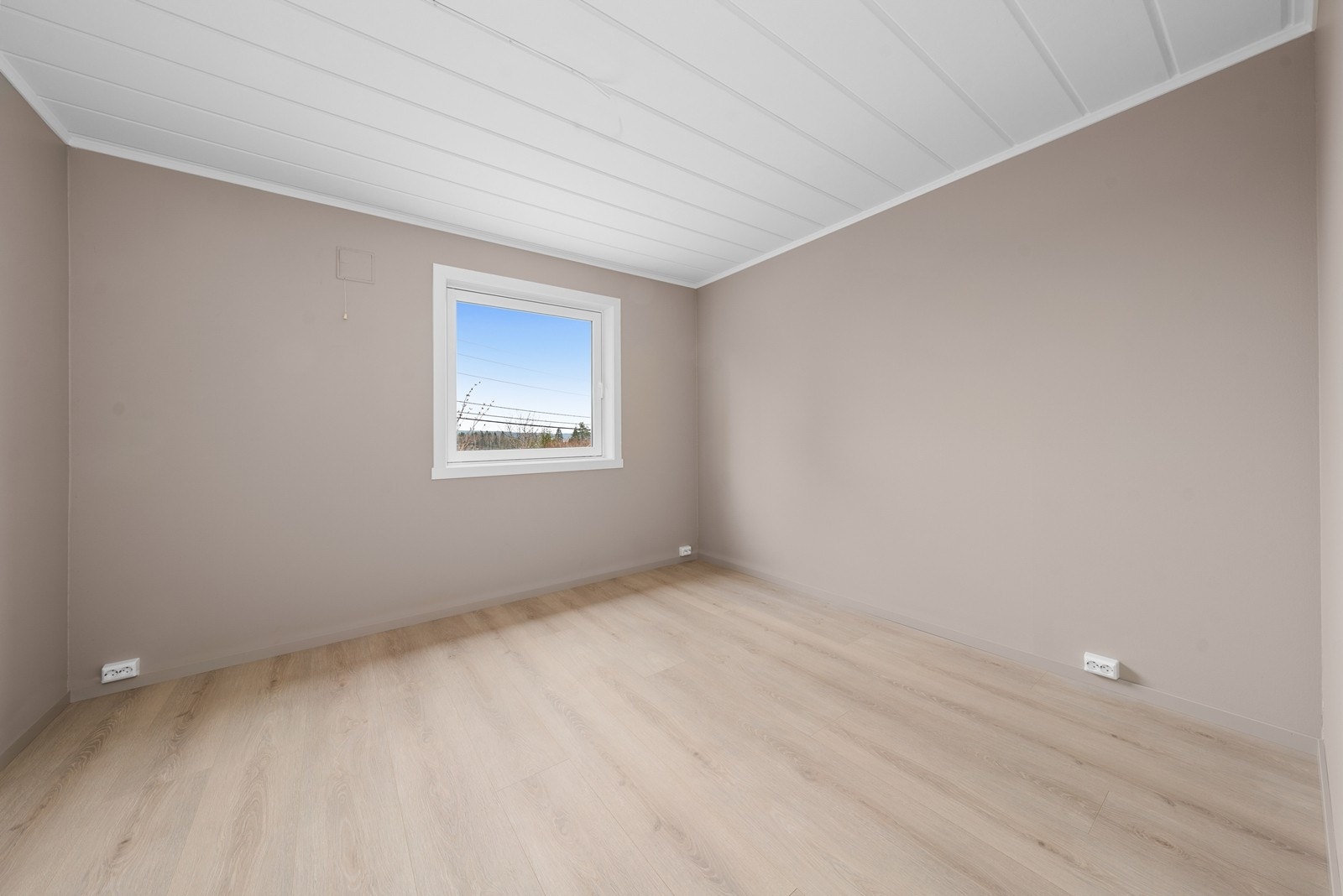 Rommet har malte, glatte flater og laminat på gulvet. Galleribilde