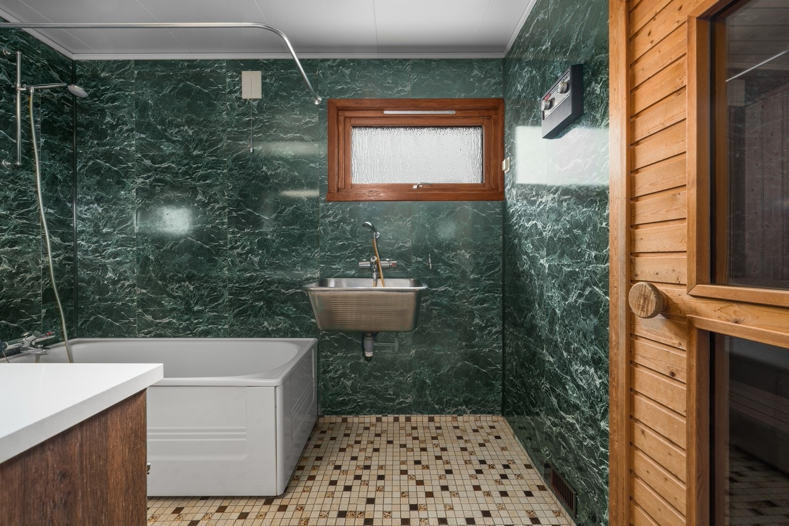 Badet i første etasje har gulvvarme, våtromsplater på veggene, badekar og en praktisk utslagsvask i stål. Galleribilde