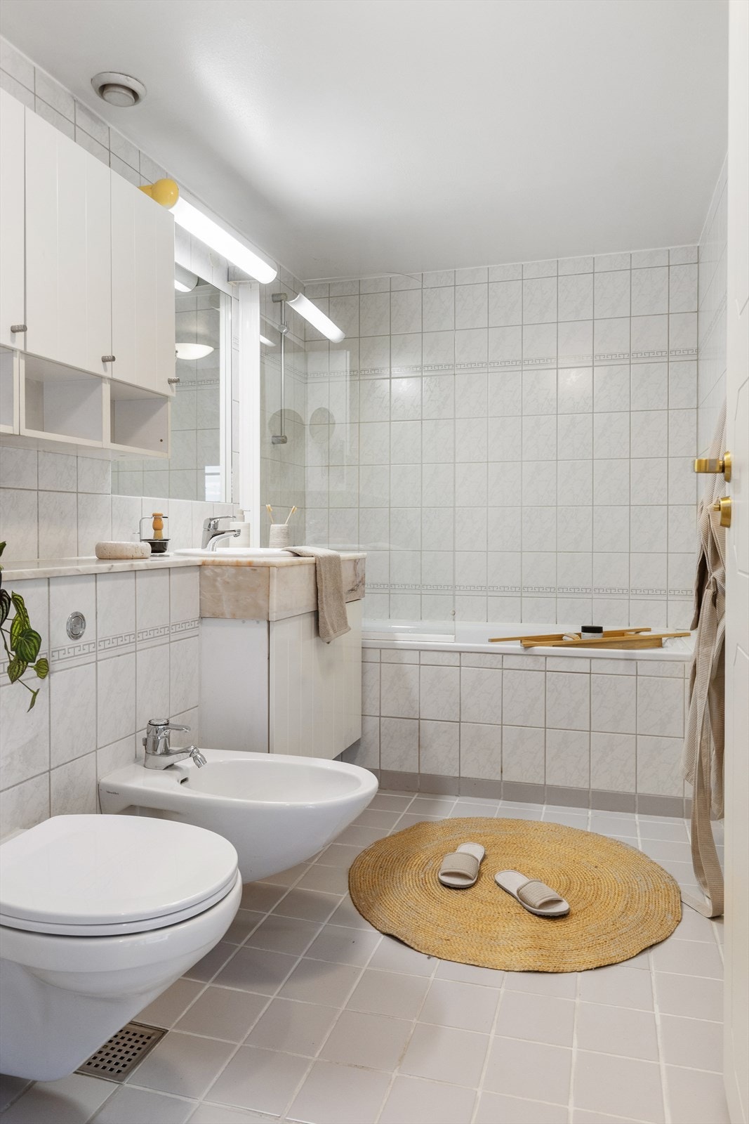 Helfliset bad fra byggeåret med gulvvarme for økt komfort. Rommet er utstyrt med badekar og vegghengt toalett. Galleribilde