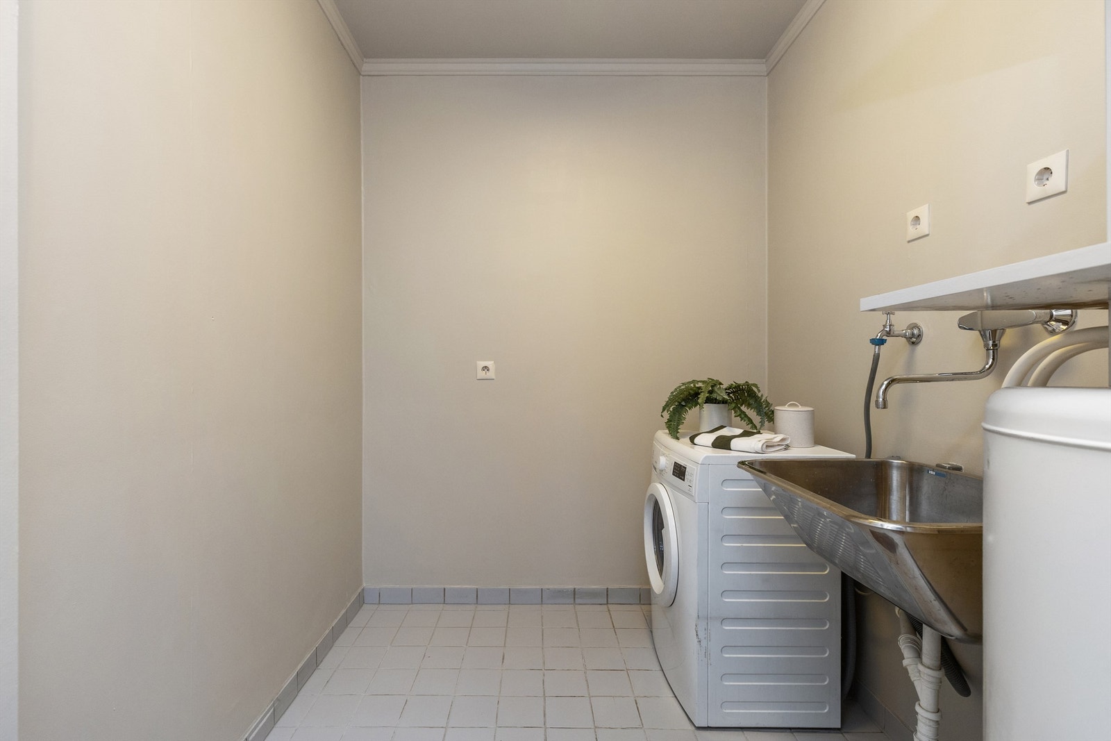 Et stort og praktisk vaskerom med flislagt gulv, utslagsvask og opplegg for vaskemaskin. Varmtvannsberederen på 200L fra 2006 er også plassert her. Galleribilde