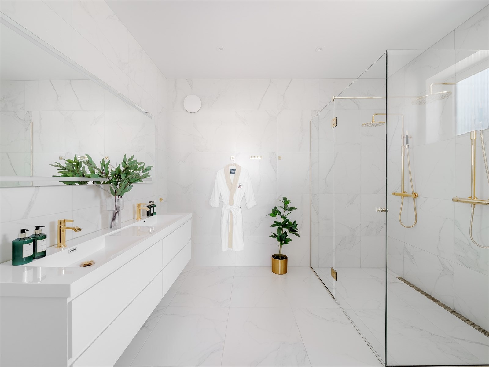 Rålekkert, helfliset baderom med dobbel servant og romslig dobbel dusj og elegante detaljer i gull . Galleribilde