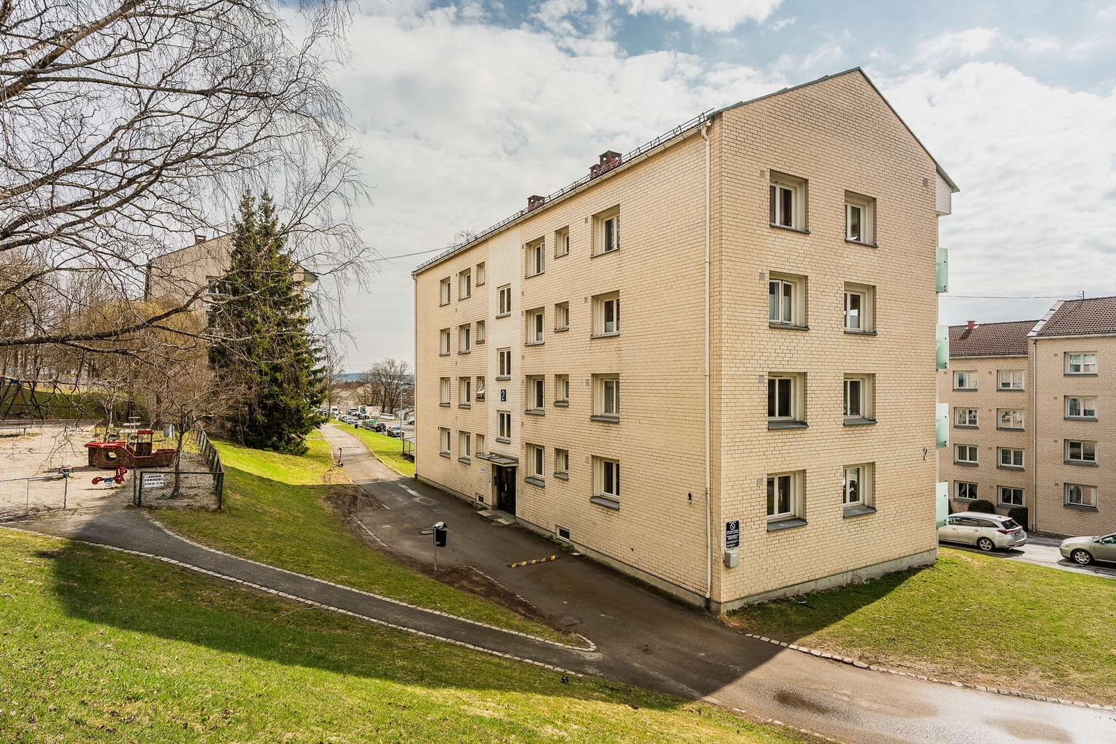 Boligblokken fra 1957 er omgitt av grønne fellesarealer og har umiddelbar nærhet til turstiene i Lillomarka. Galleribilde