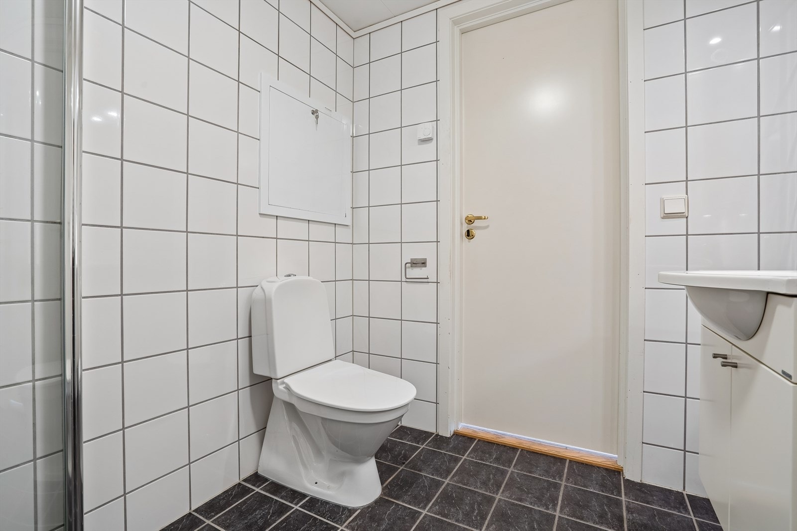 Badet er utstyrt med klosett, servantskap med servant, dusj med glassdører, opplegg for vaskemaskin, rørfordelingsskap og mekanisk avtrekk. Galleribilde