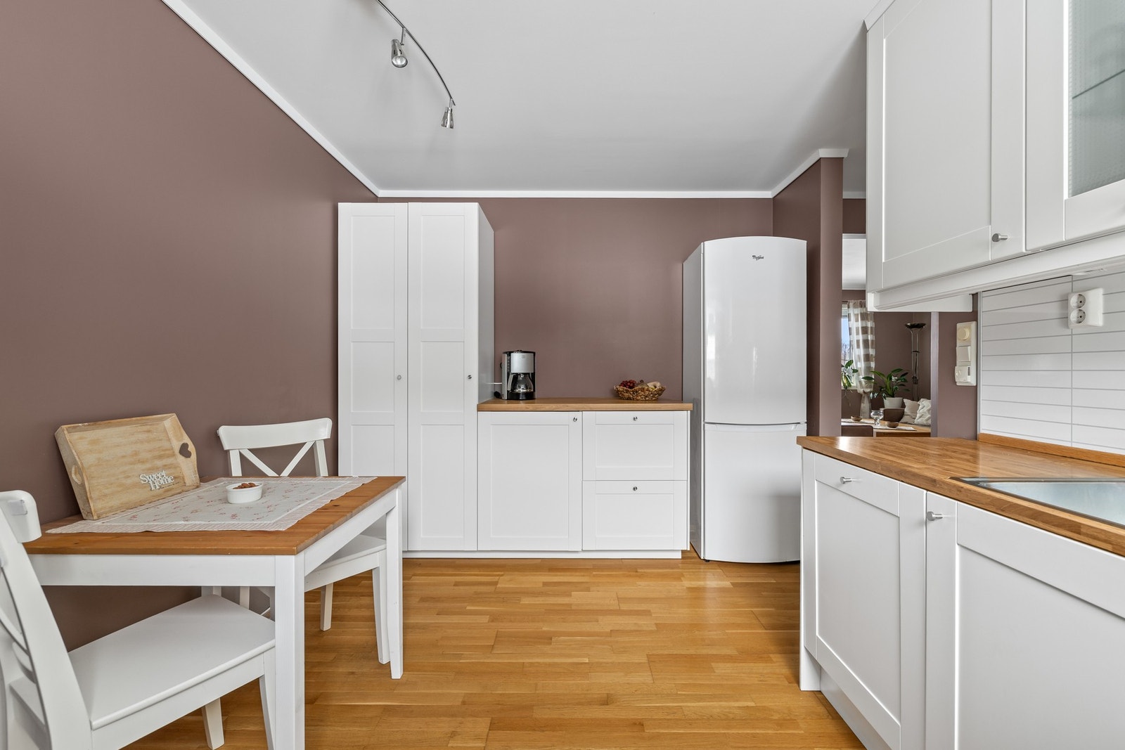 Innredningen har hvite, profilerte fronter, vitrineskap, nedfelt oppvaskkum og benkeplate av laminat. Galleribilde