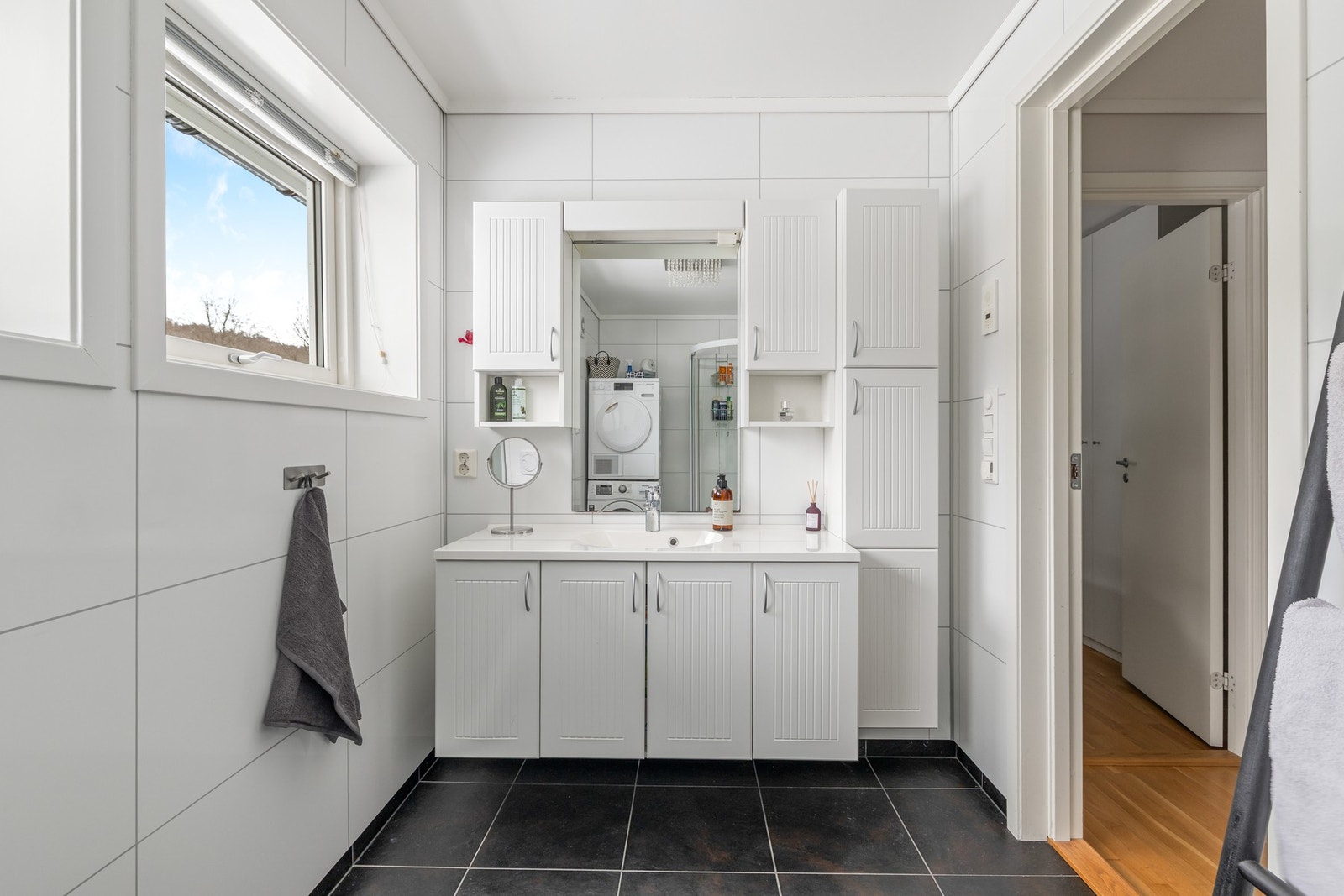 Opplegg for vaskemaskin er etablert, og badet har varmekabler, dusjkabinett og vegghengt toalett. Galleribilde