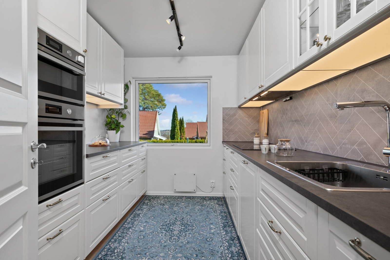 Kjøkkenet ble oppgradert i 2023 og har Ikea-innredning med profilerte fronter og laminat benkeplate med nedfelt kum. Kjøkkenet er utstyrt med integrerte hvitevarer som oppvaskmaskin, induksjonstopp, stekeovn og mikro. Galleribilde