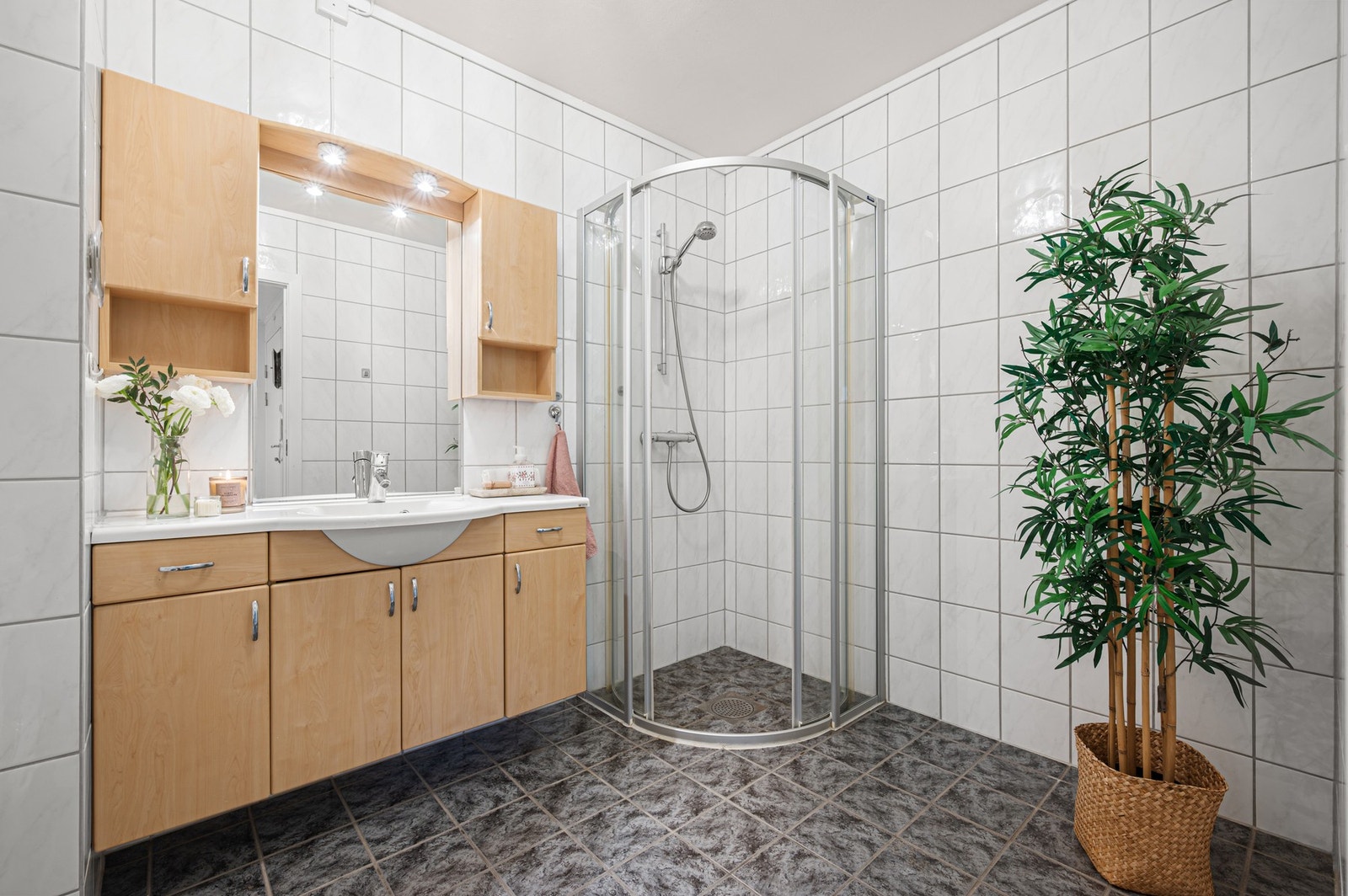 Flislagt bad med god plass til oppbevaring i baderomsinnredning. Galleribilde