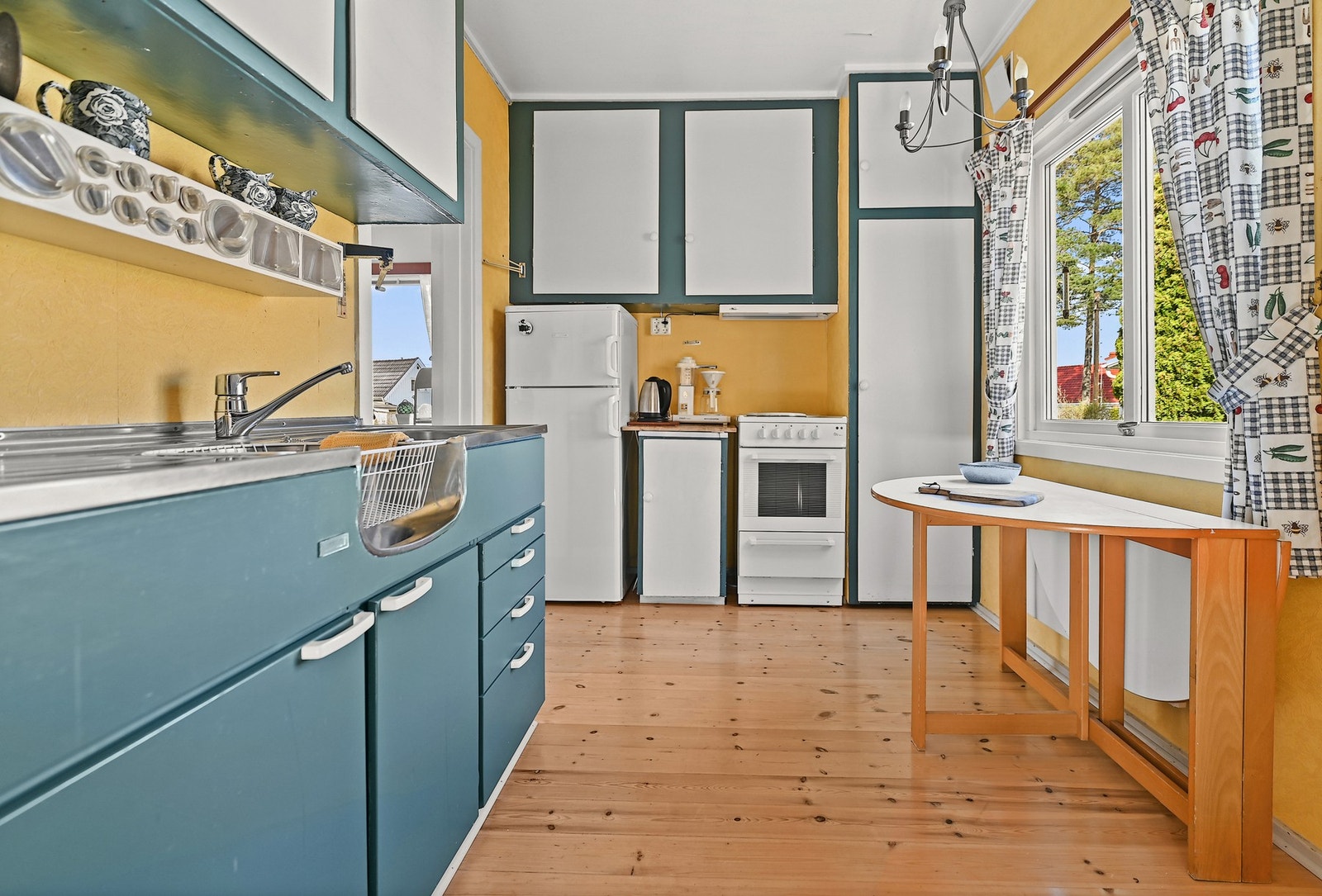 Kjøkkenet er innredet med malt kjøkkeninnredning og benkeplate i stål. Frittstående hvitevarer. Galleribilde