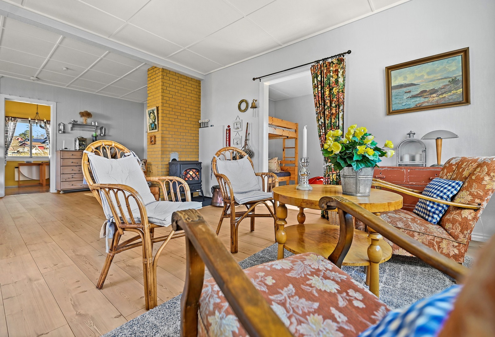 Sentralt i rommet er det vedovn som varmer godt, og gir mye kos og hygge på mørke høst- og vinterkvelder. Galleribilde