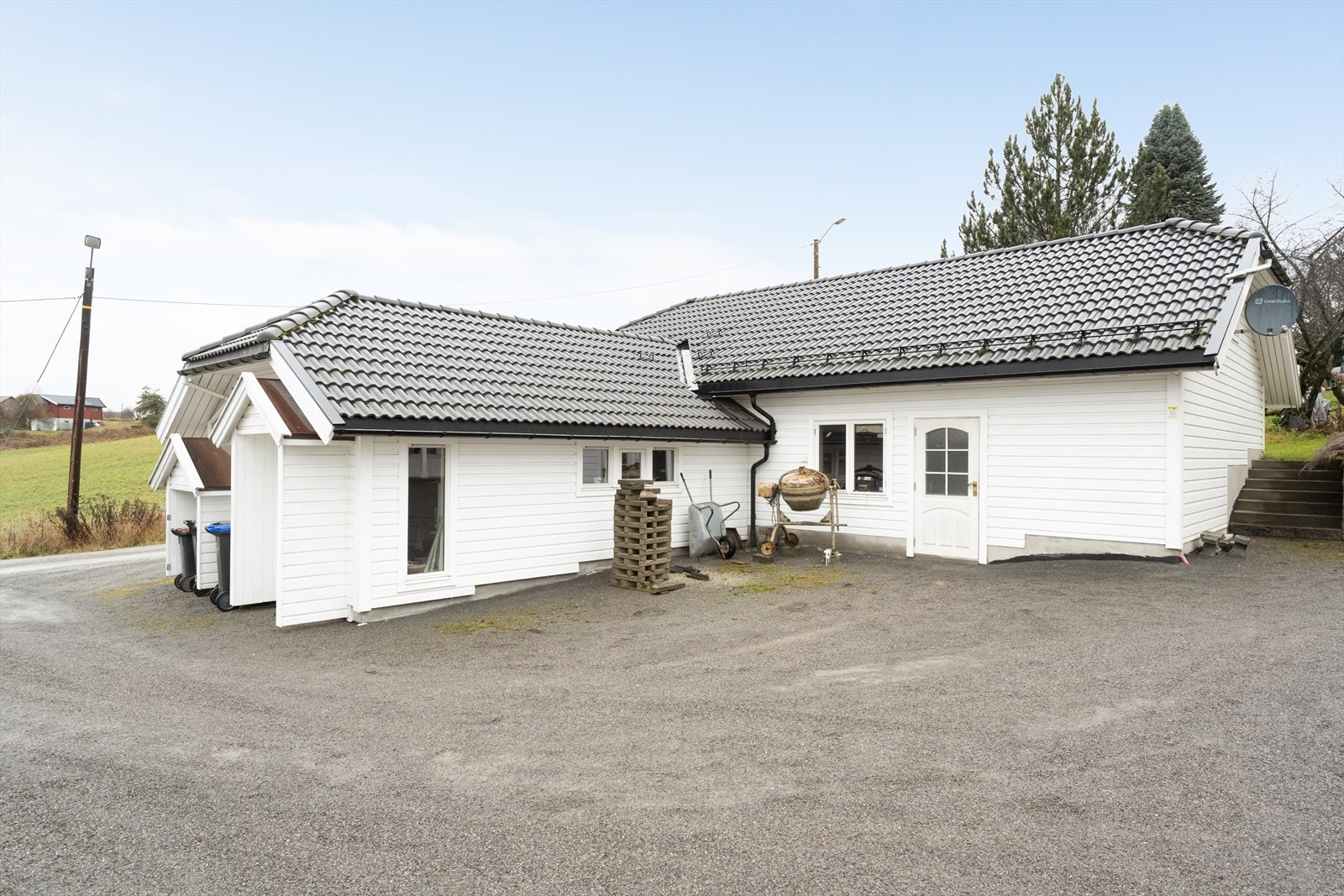 Garasjebygningen har liggende trekledning og taktekking i betongtakstein, i stil med hovedhuset. Galleribilde