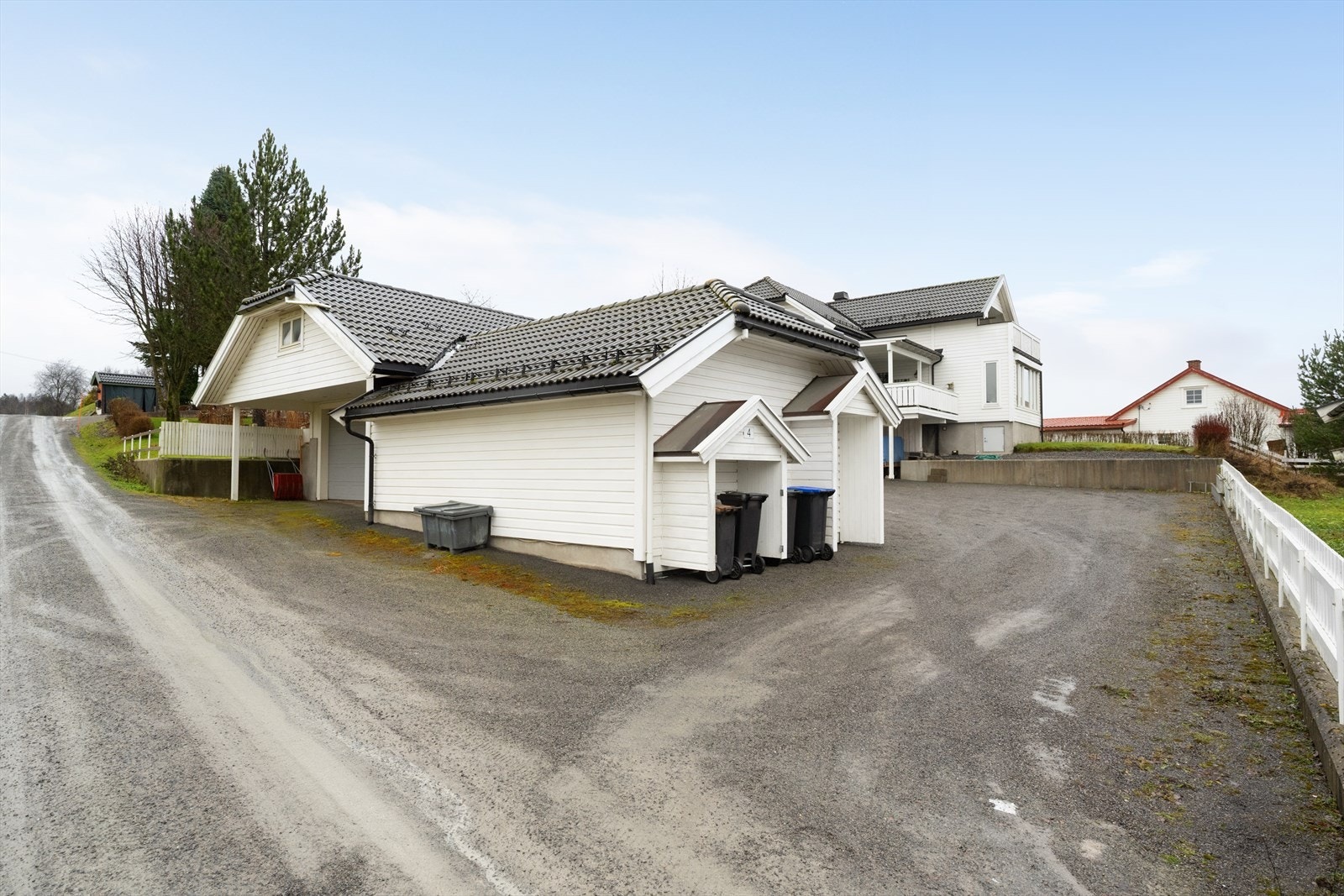 Stor, gruset gårdsplass med rikelig av biloppstillingsplasser foran både bolig og garasje. Galleribilde