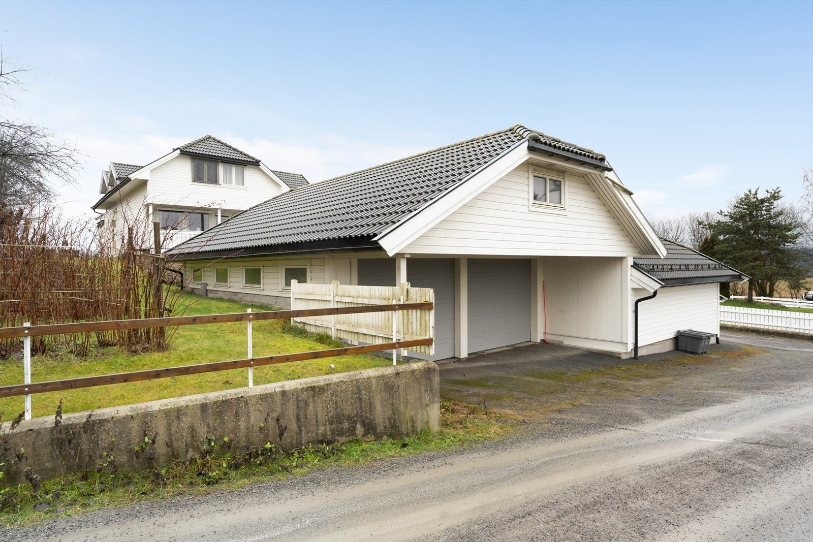 Eiendommen inkluderer en separat garasjebygning på 93 m² med hobbyrom, garasje, bod og kjølerom. Galleribilde