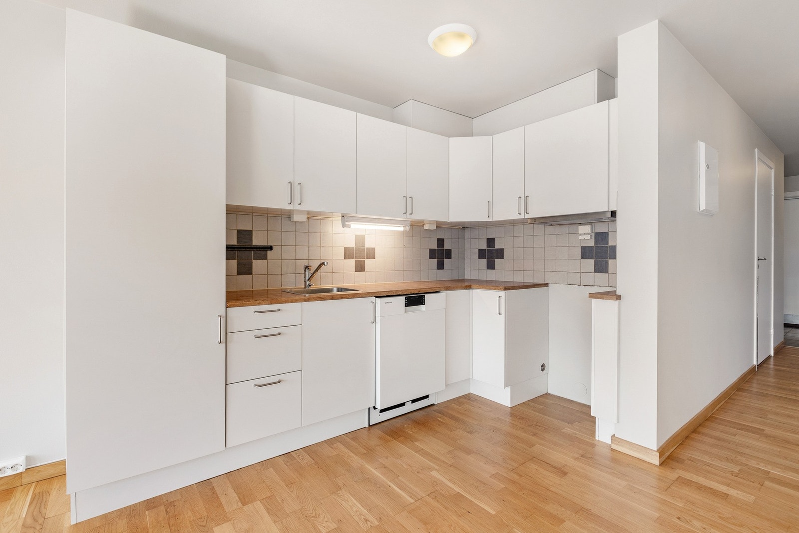 Kjøkkenet har en praktisk og tidløs utforming med innredning i glatte, lyse fronter som gir et rent og moderne utrykk. Galleribilde