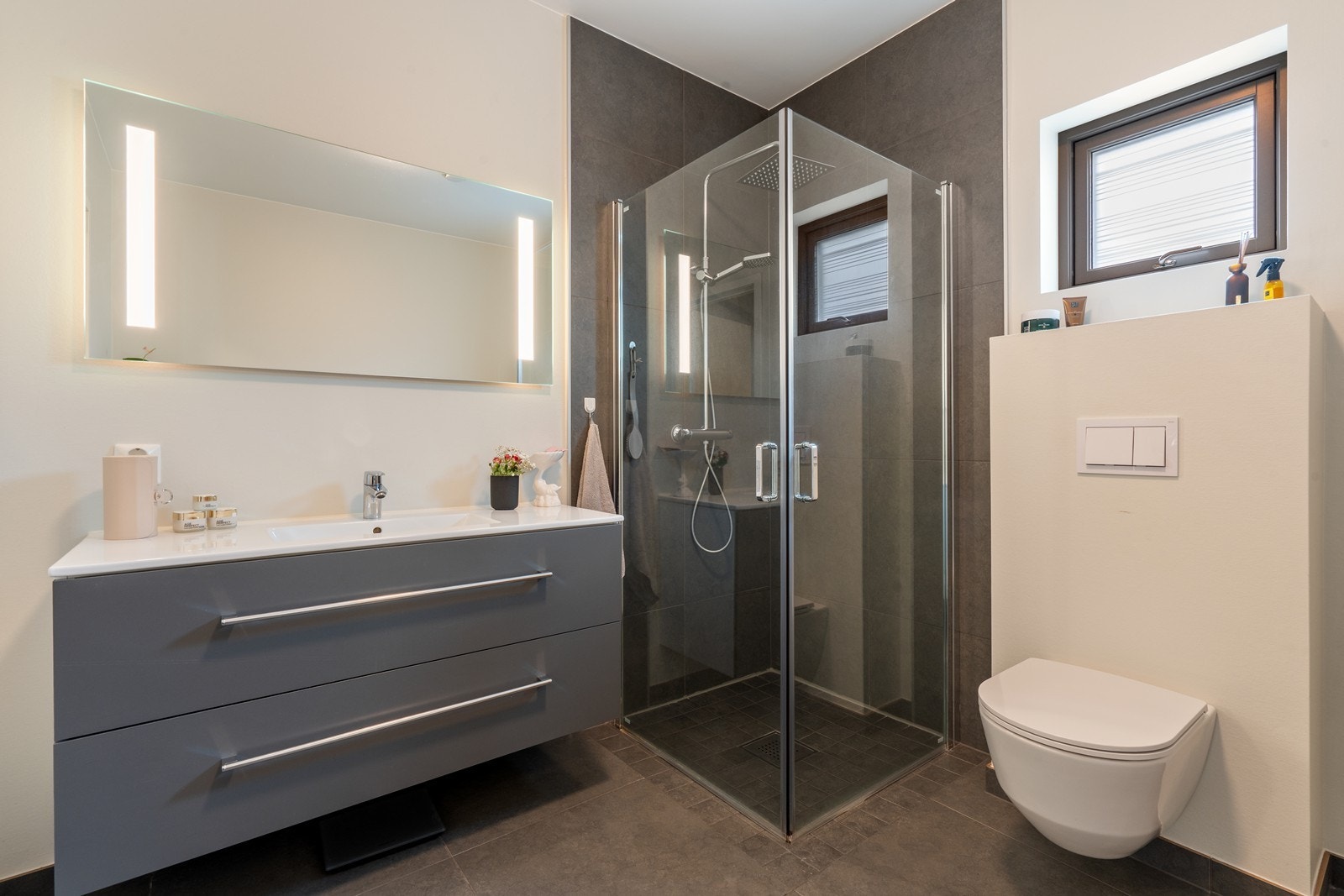 Badet er innredet med dusj, vask i seksjon og vegghengt wc. Galleribilde