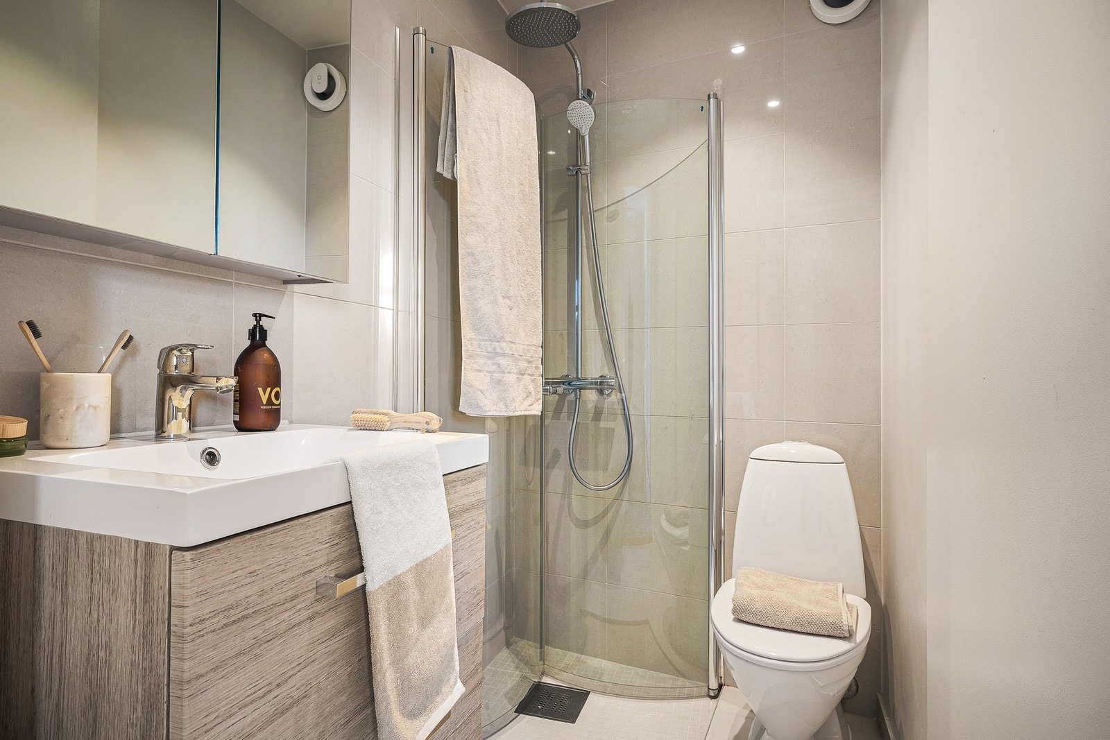 Badet på 2,2 kvm er flislagt på gulv og deler av veggene, og har innredning med toalett, dusjhjørne og skuffeseksjon med overliggende servant. Avtrekk skjer via el-vifte. Galleribilde