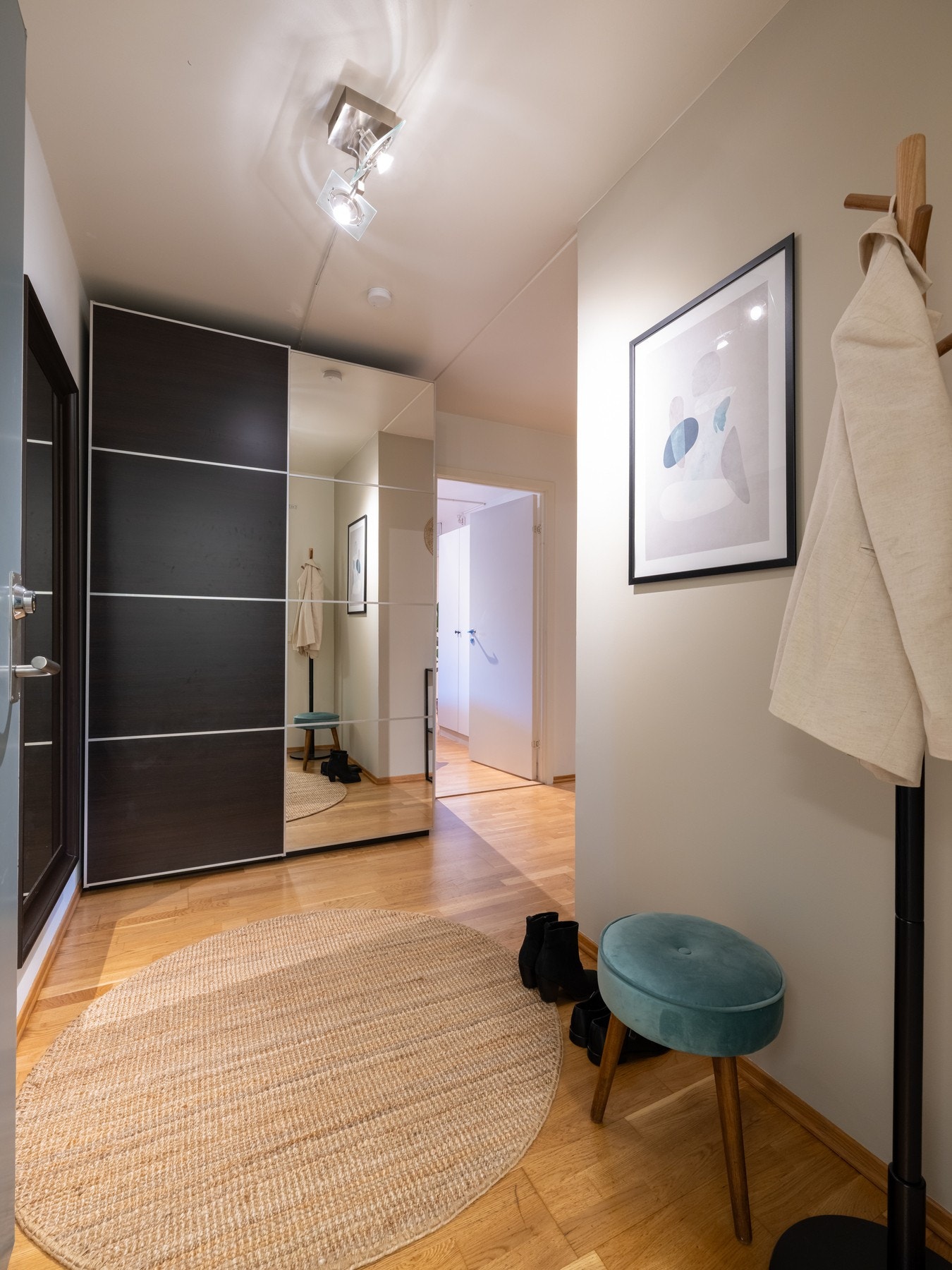 Lys entré med parkett på gulv og malte overflater. Her er det plass til blant annet knaggrekker, speil og skostativ. Galleribilde
