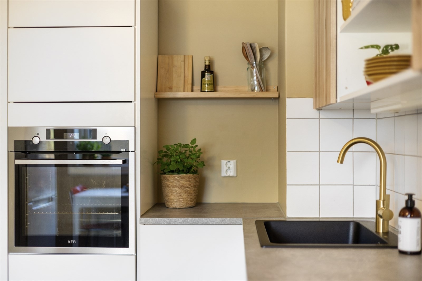 Kjøkkenet har integrerte hvitevarer som oppvaskmaskin, koketopp (ny i 2025) og kjøl/fryseskap, samt stekeovn plassert i praktisk arbeidshøyde i høyskap. Galleribilde