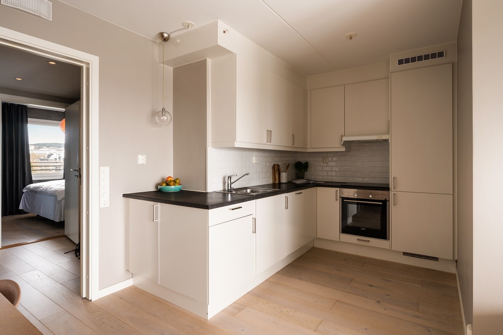 Pen innredning fra Sigdal med glatte fronter. Laminat benkeplate med oppvaskkum og ettgreps, svingbart blandebatteri. Galleribilde