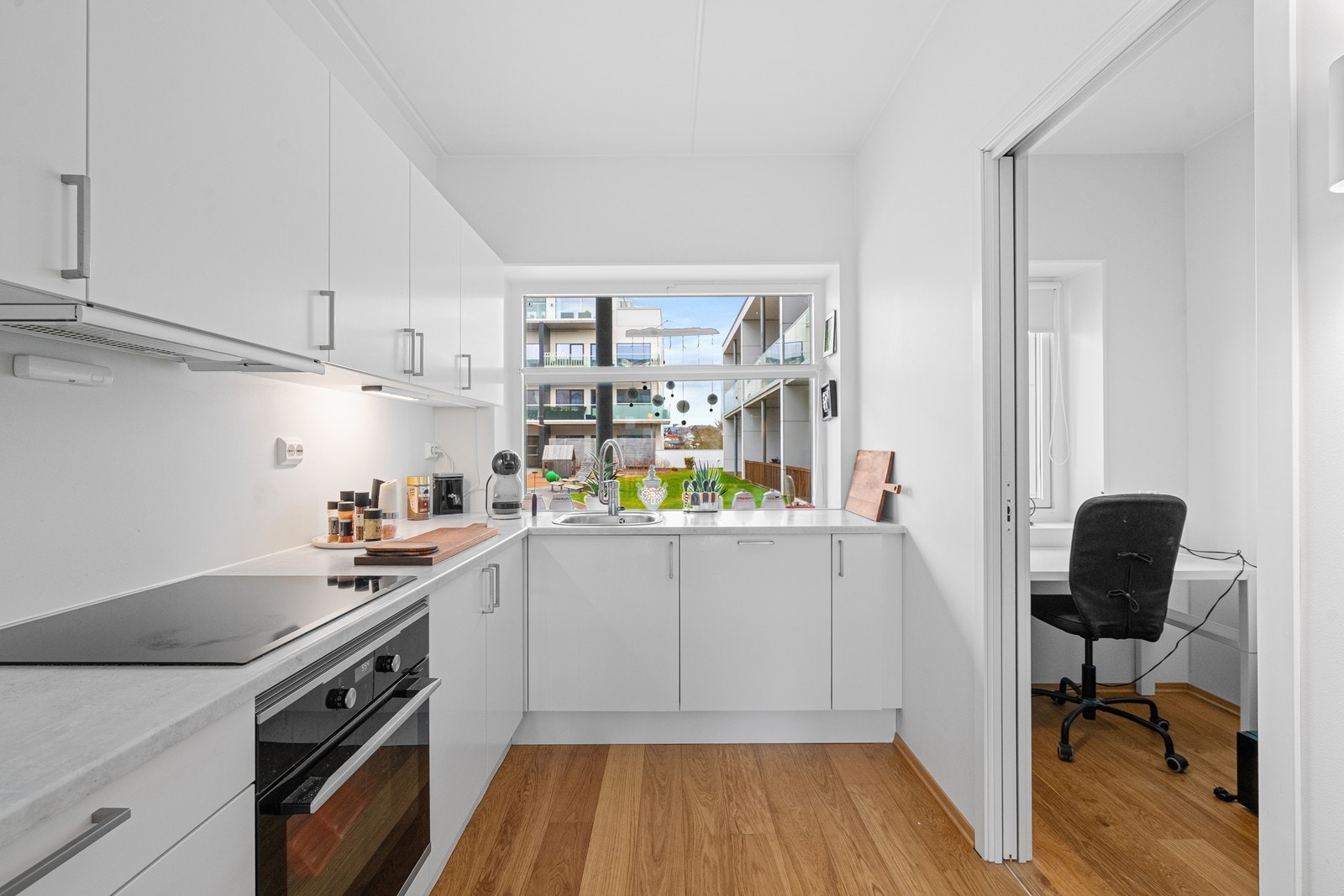Kjøkkenet har rikelig med skap- og benkeplass og skyvedør ut til det ene soverommet. Galleribilde
