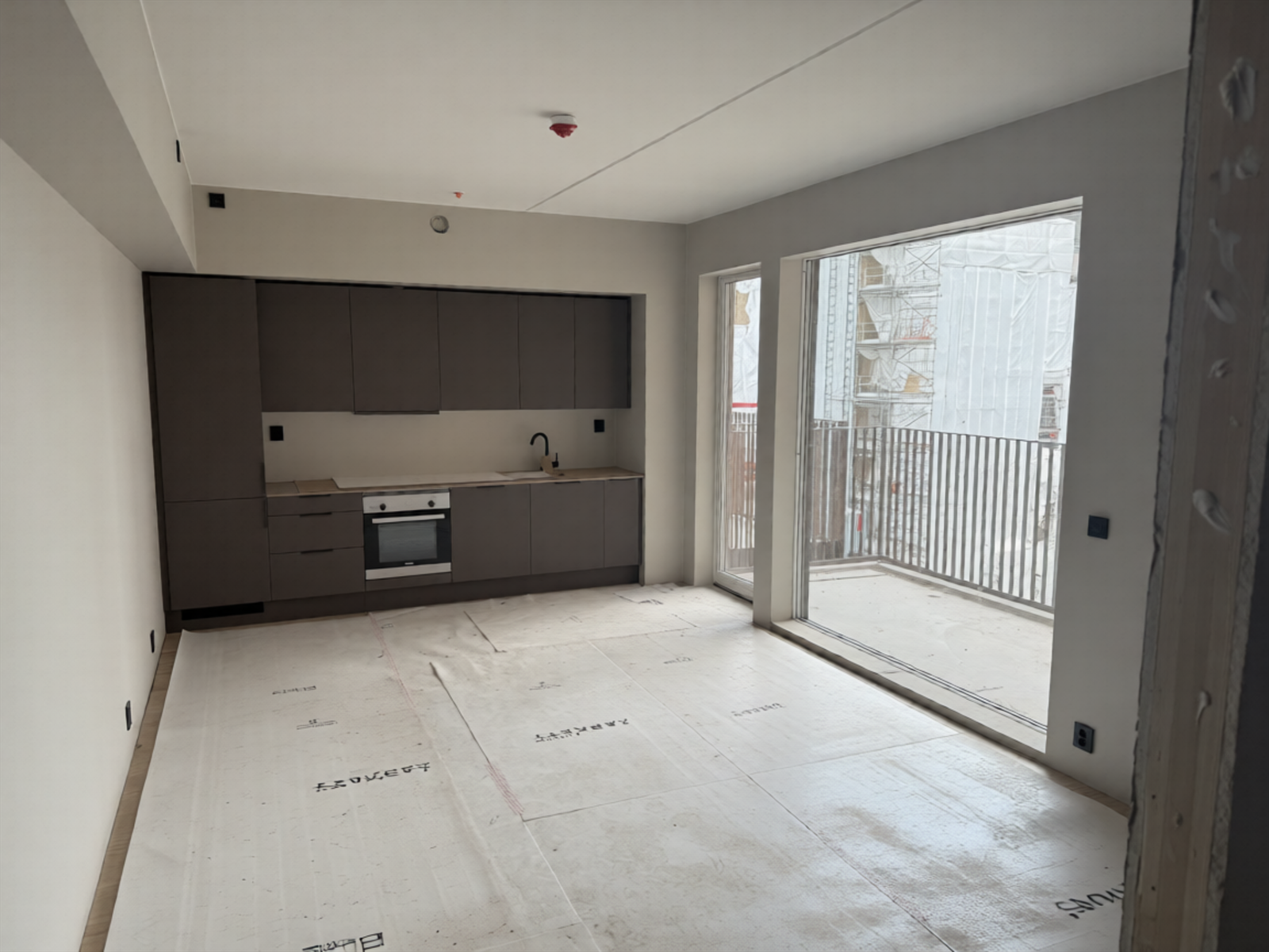 Stue på ca. 23,7 m² med åpen kjøkkenløsning. Kjøkken fra HTH med integrerte hvitevarer fra Siemens. Bilde tatt på byggeplassvisning 13/4-2026. Galleribilde