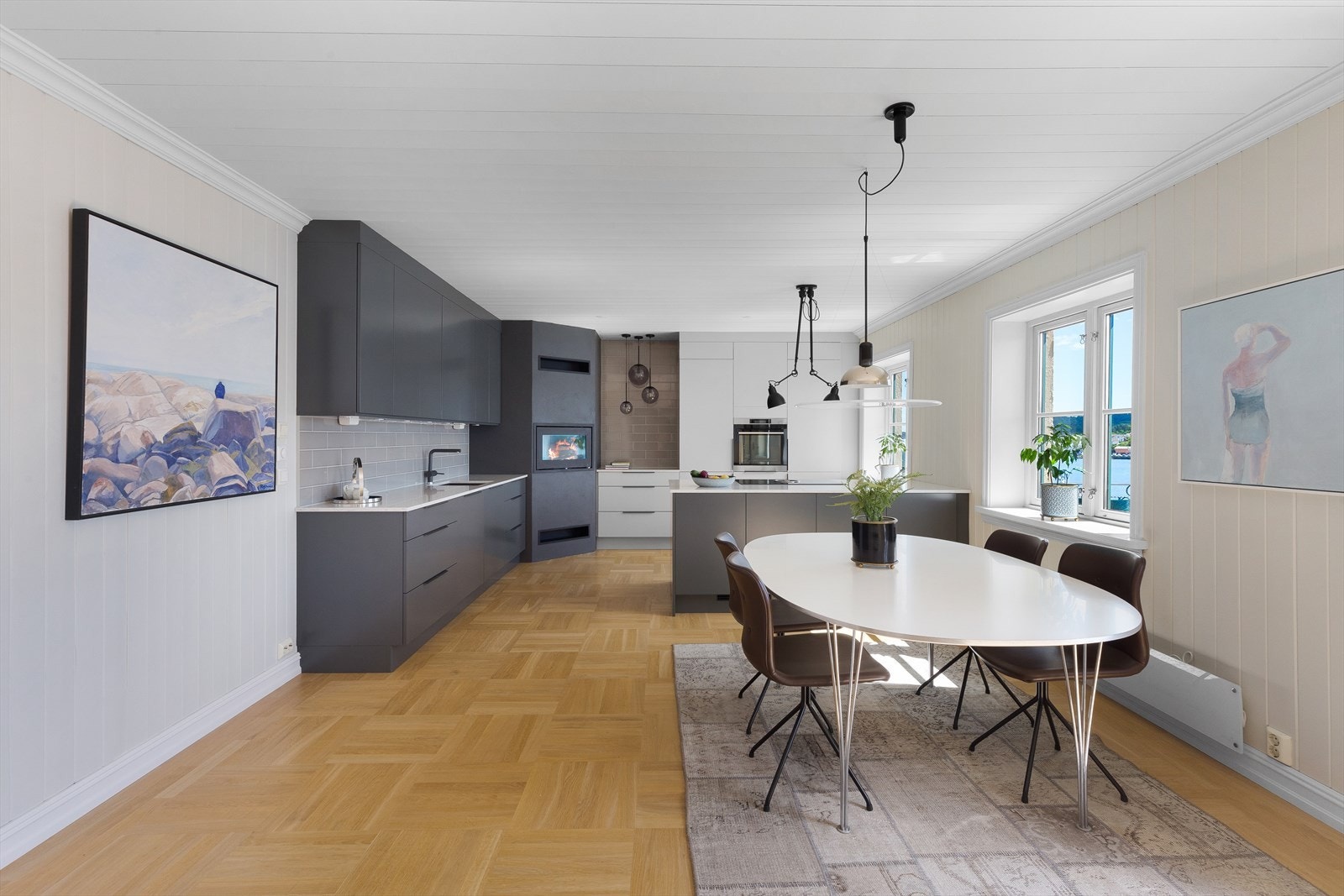Kjøkkenet er oppgradert i 2019 med stor innredning fra Strai i moderne og stilfult design, Silestone benkeplater, matchende glatte fronter i gråtoner, fliser over benk, hjørnepeis og halvøy med barløsning. Galleribilde
