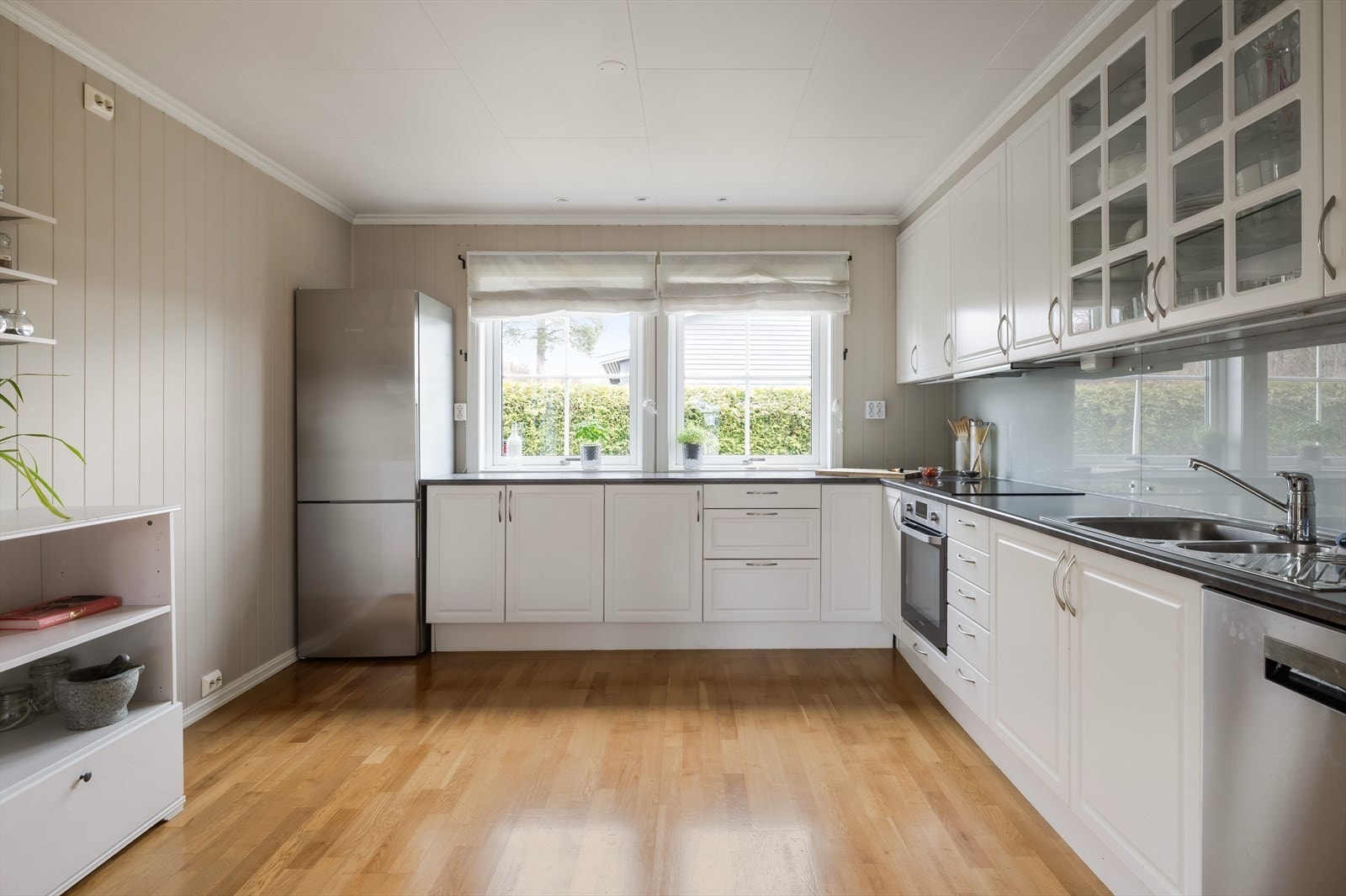 Kjøkkeninnredning er utstyrt med laminert benkeplate, ettgreps blandebatteri, to rustfrie kummer, integrert koketopp og oppvaskmaskin. Galleribilde