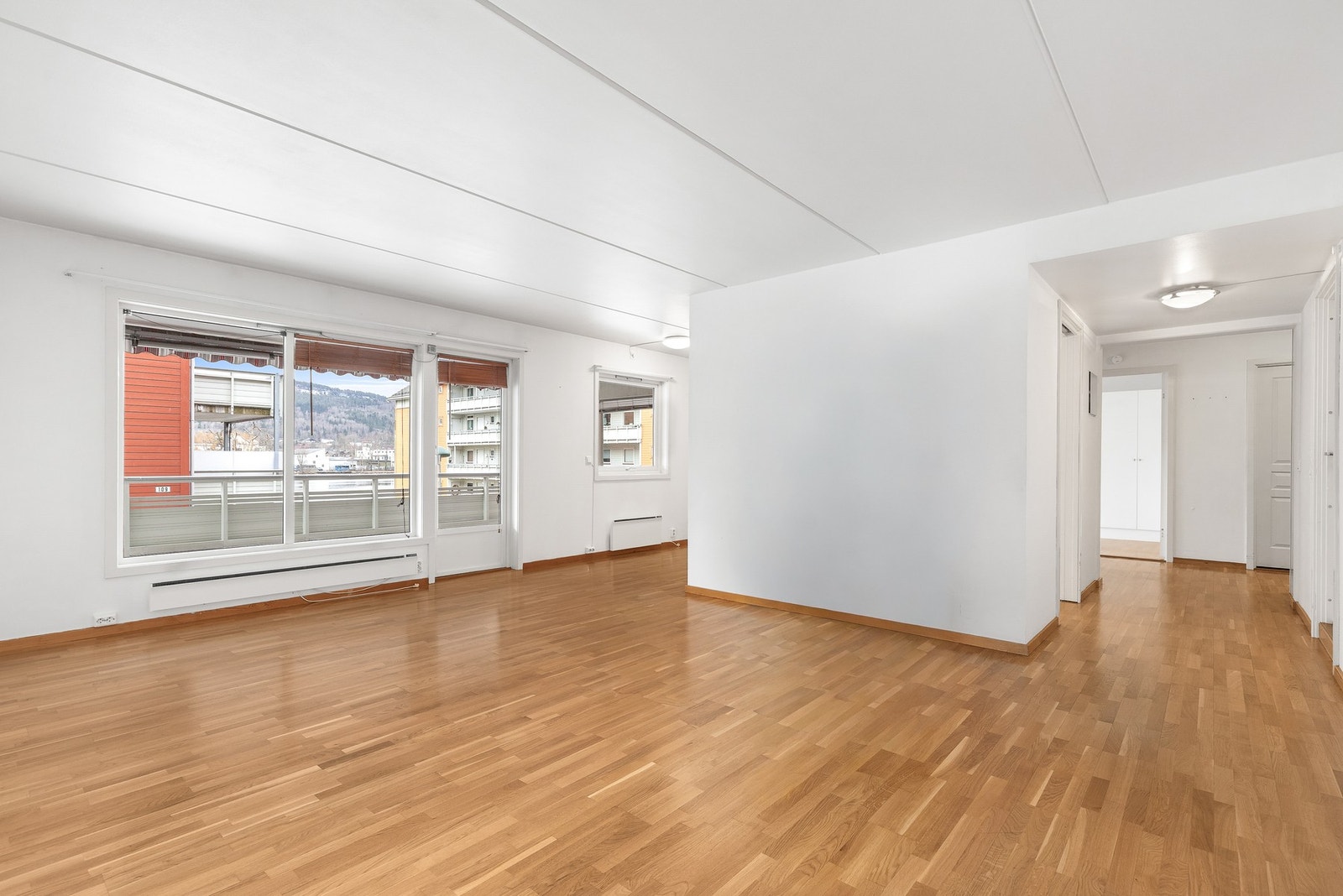 Leiligheten har en lys og luftig stue med store vindusflater og delvis åpen kjøkkenløsning Galleribilde