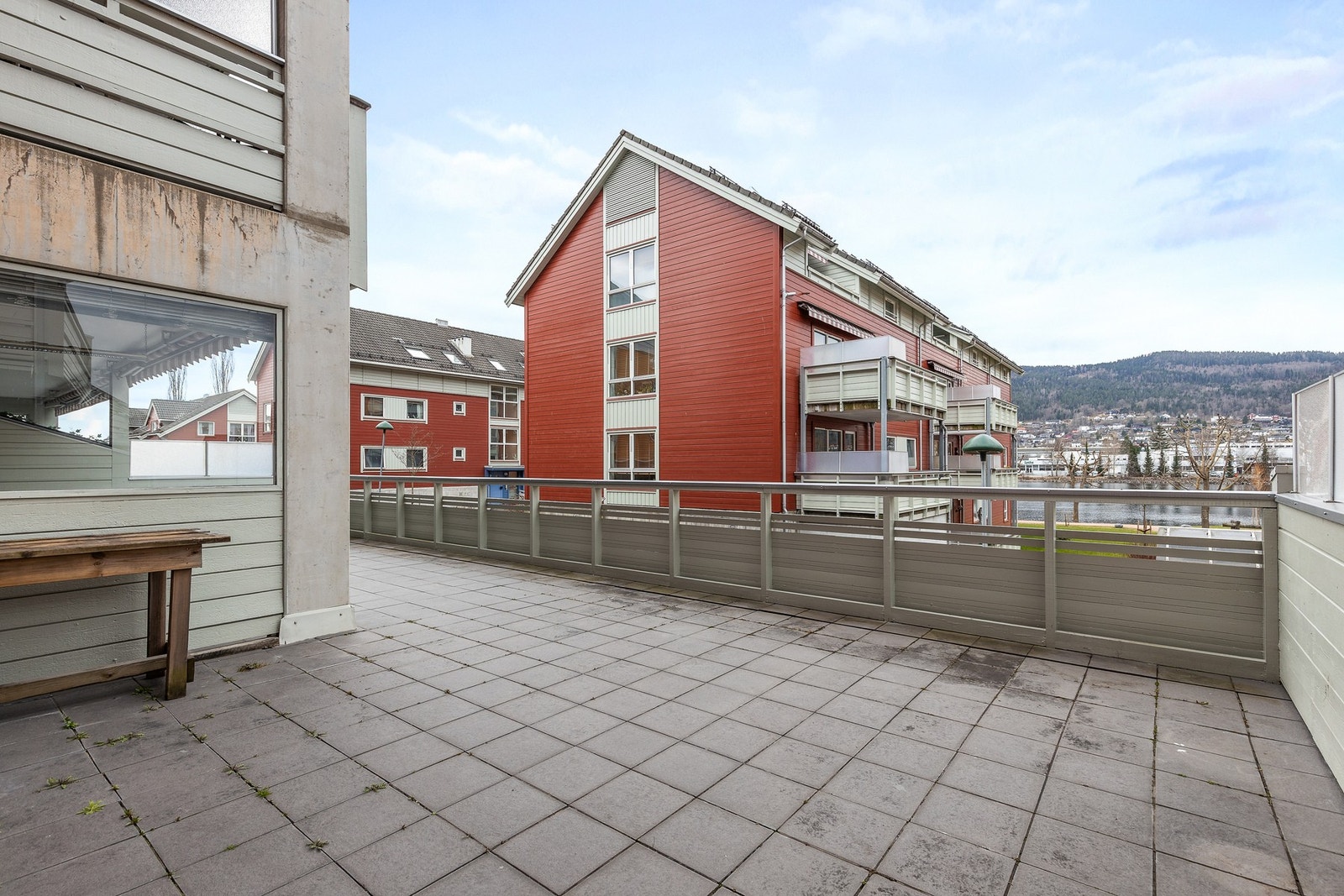 Terrassen er oppført i betong og har rekkverk med liggende bord samt flis på gulv Galleribilde