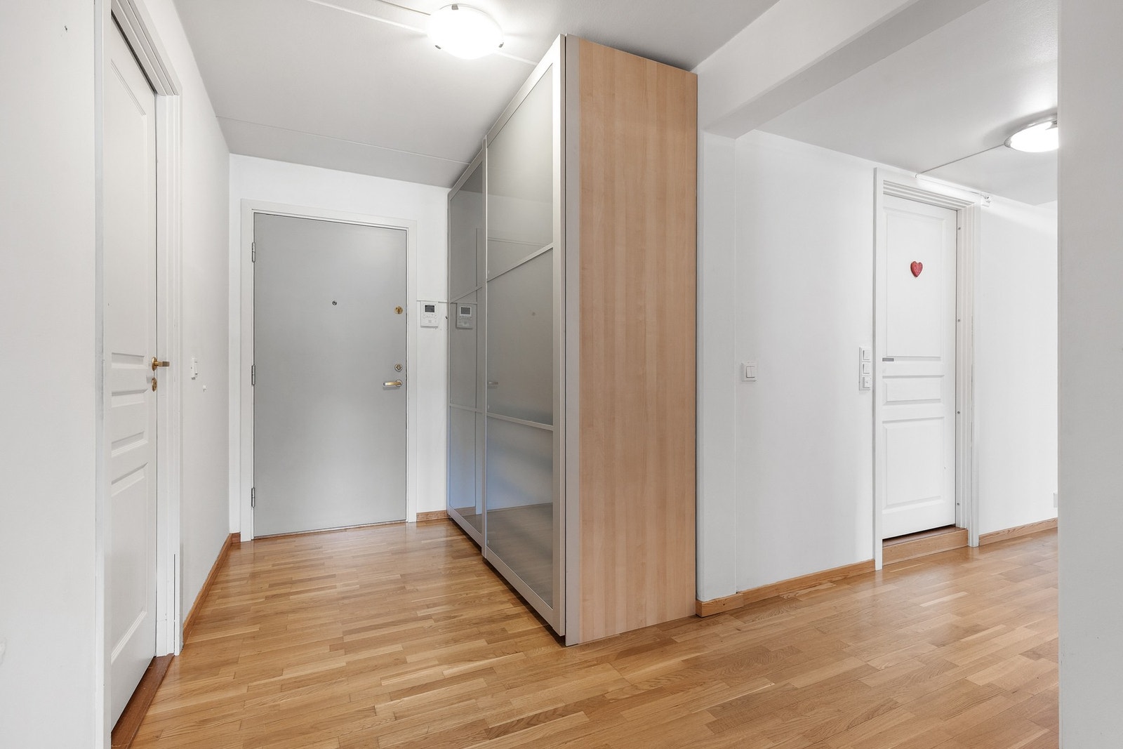 Romslig entré med skyvedørsgarderobe og porttelefon Galleribilde