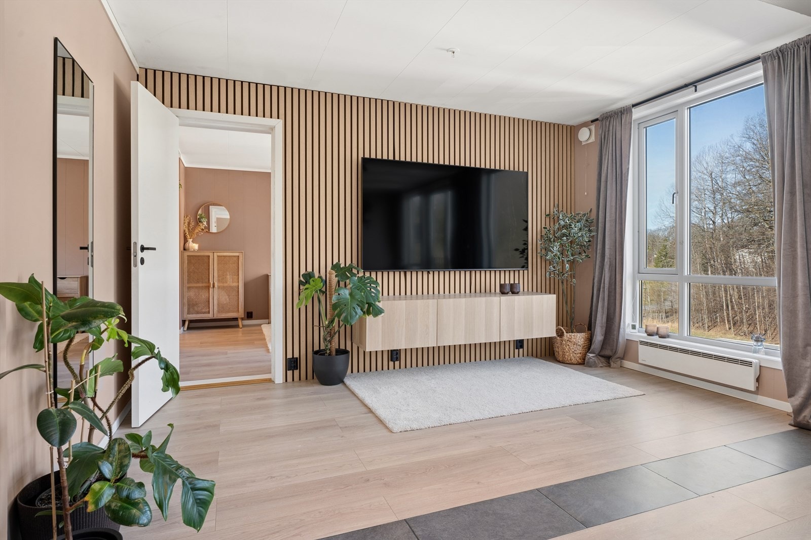 Stuen har en moderne spilevegg som skaper et lunt og definert område for TV-sonen. Galleribilde
