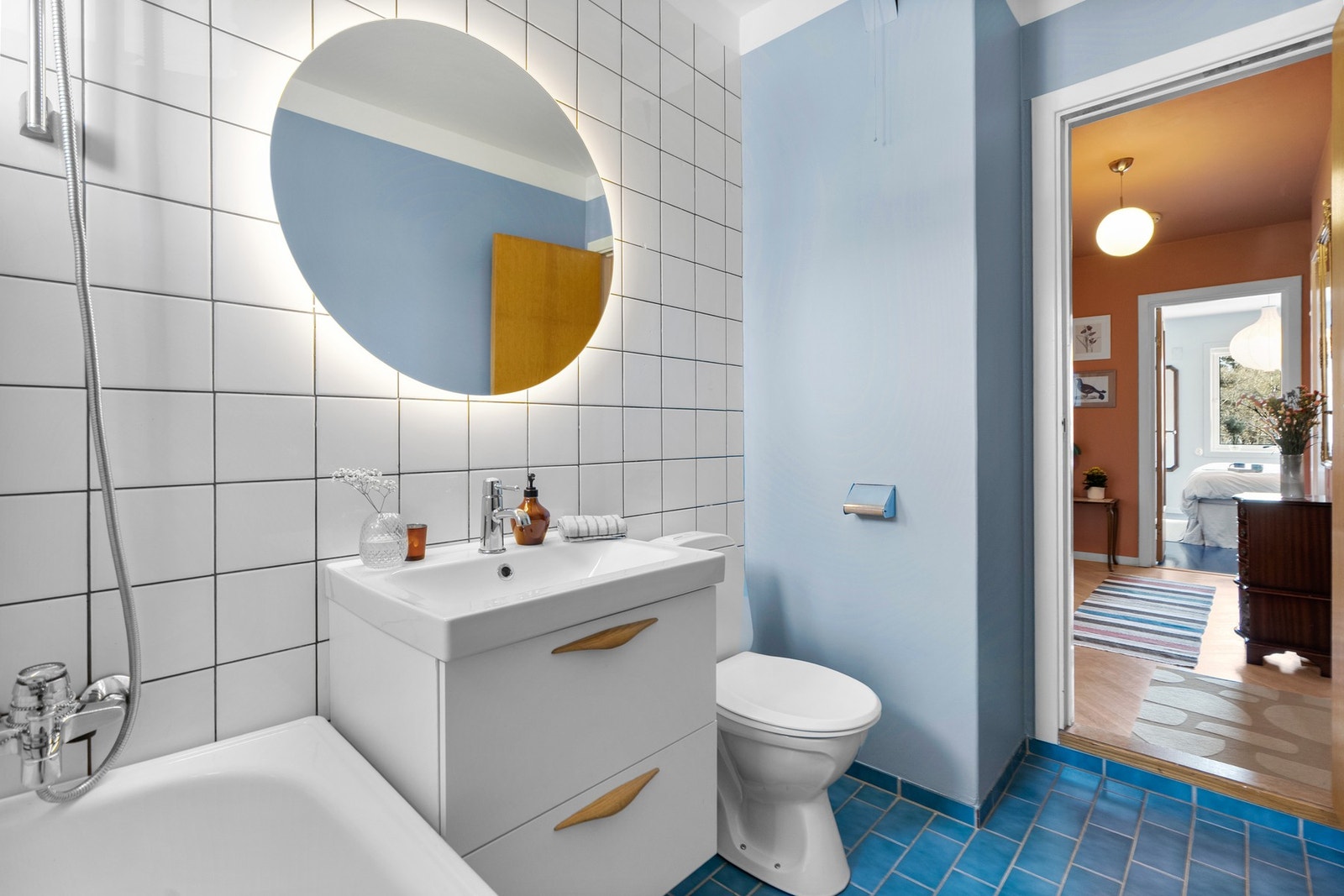 Badet inneholder servantskap med glatte fronter, speil med lysarmatur over servant, gulvmontert klosett og badekar. Galleribilde